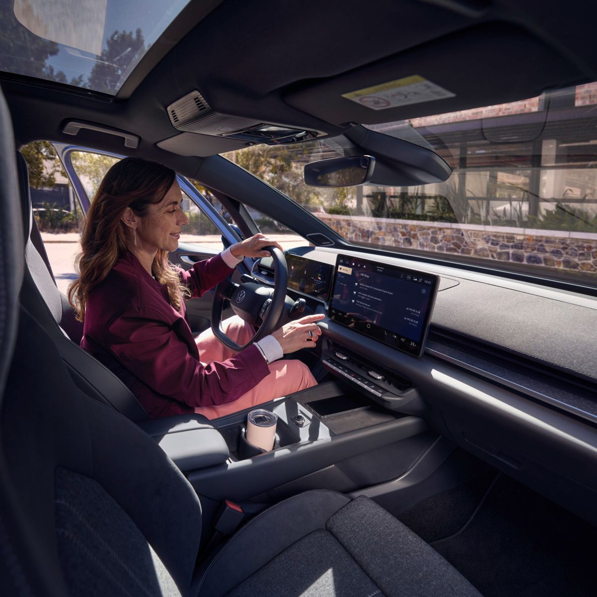 Žena vyberá online funkciu na stredovom displeji vozidla VW ID.3 Neo.