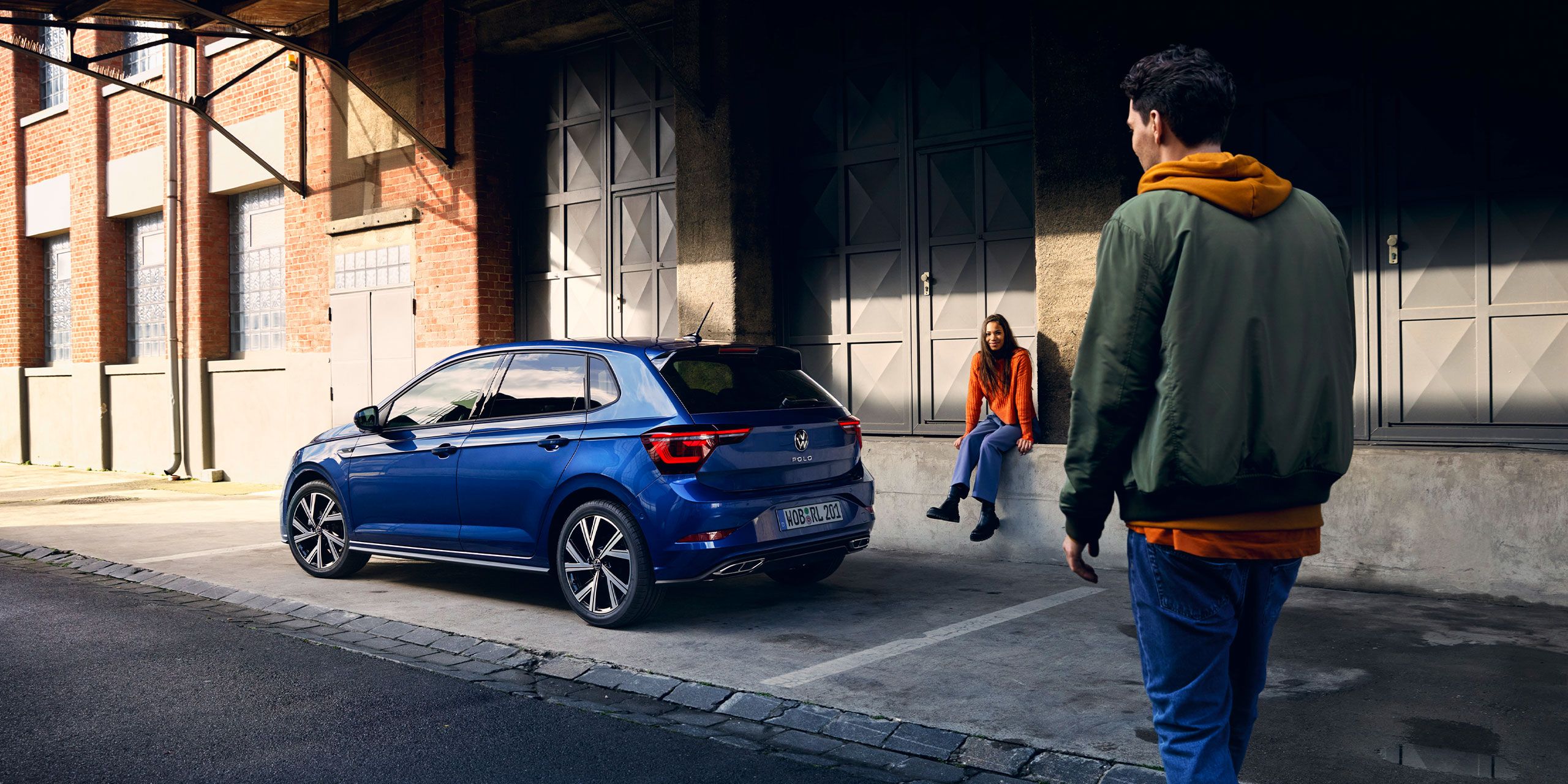 Dve osoby a zaparkované vozidlo VW Polo