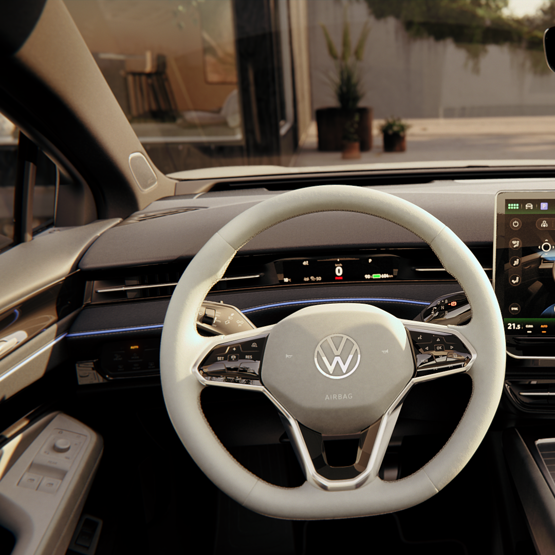 Interiér moderného automobilu značky Volkswagen so svetlým volantom a veľkým farebným dotykovým displejom na palubnej doske. Na displeji je zobrazený náhľad automobilových systémov. 