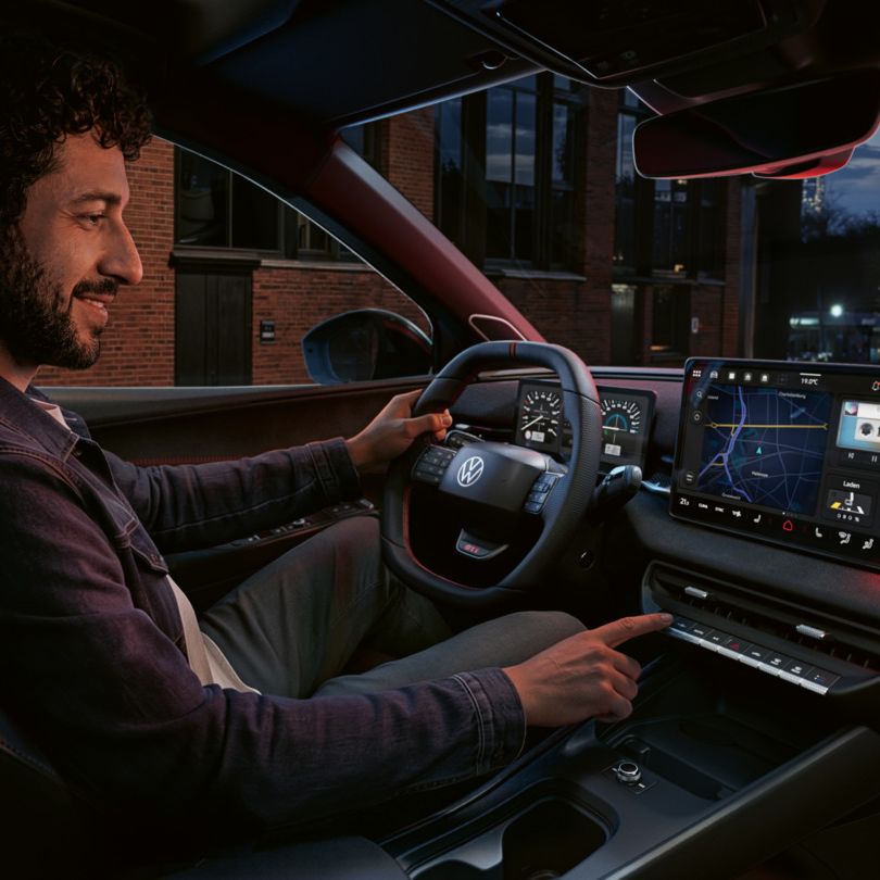 Osoba ovláda tlačidlo infotainment systému vo vozidle VW ID. Polo GTI.