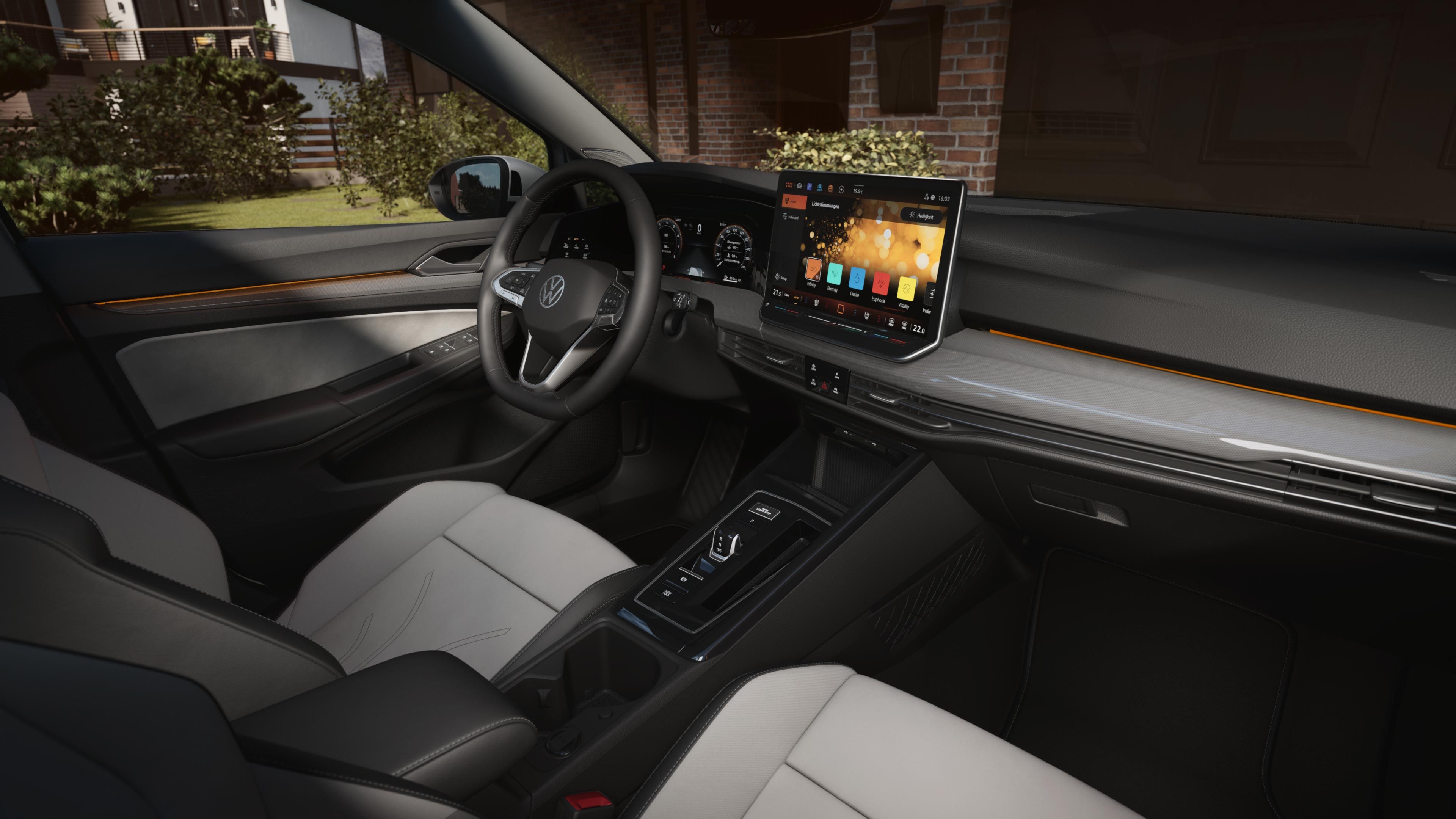Pohľad do vnútorného priestoru automobilu s čistým a elegantným dizajnom. Zahŕňa digitálny prístrojový displej, palubnú dosku s displejom systému infotainment, multifunkčný volant a mnoho ďalších ovládacích prvkov. Sedadlá sú čalúnené kožou v kombinácii bielej a čiernej kože.