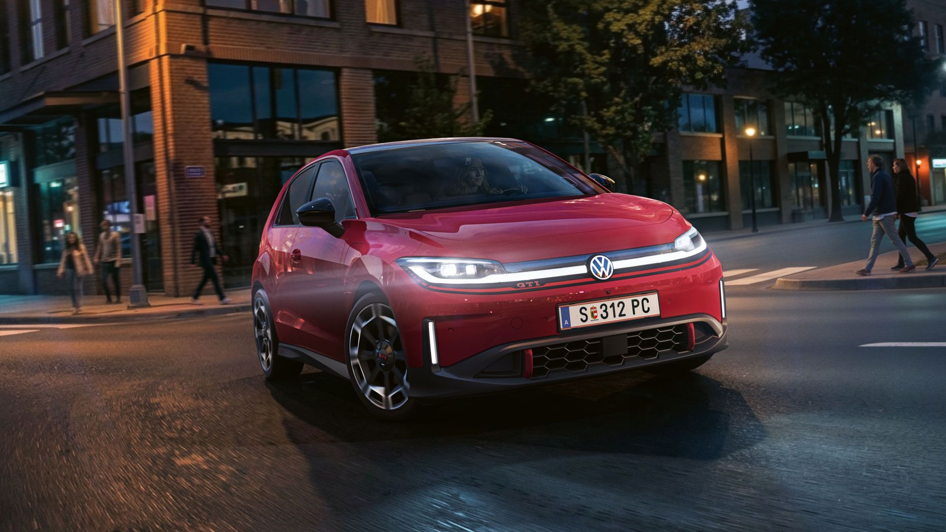 Červený VW ID. Polo GTI odbočuje na križovatke pri večernom svetle.