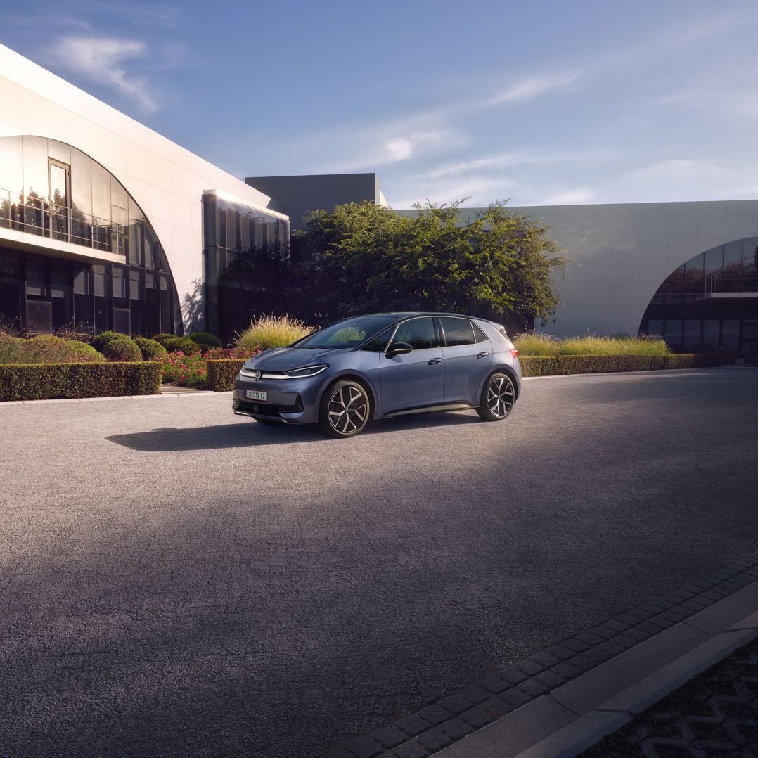 Modrý VW ID.3 Neo parkuje pred modernou budovou