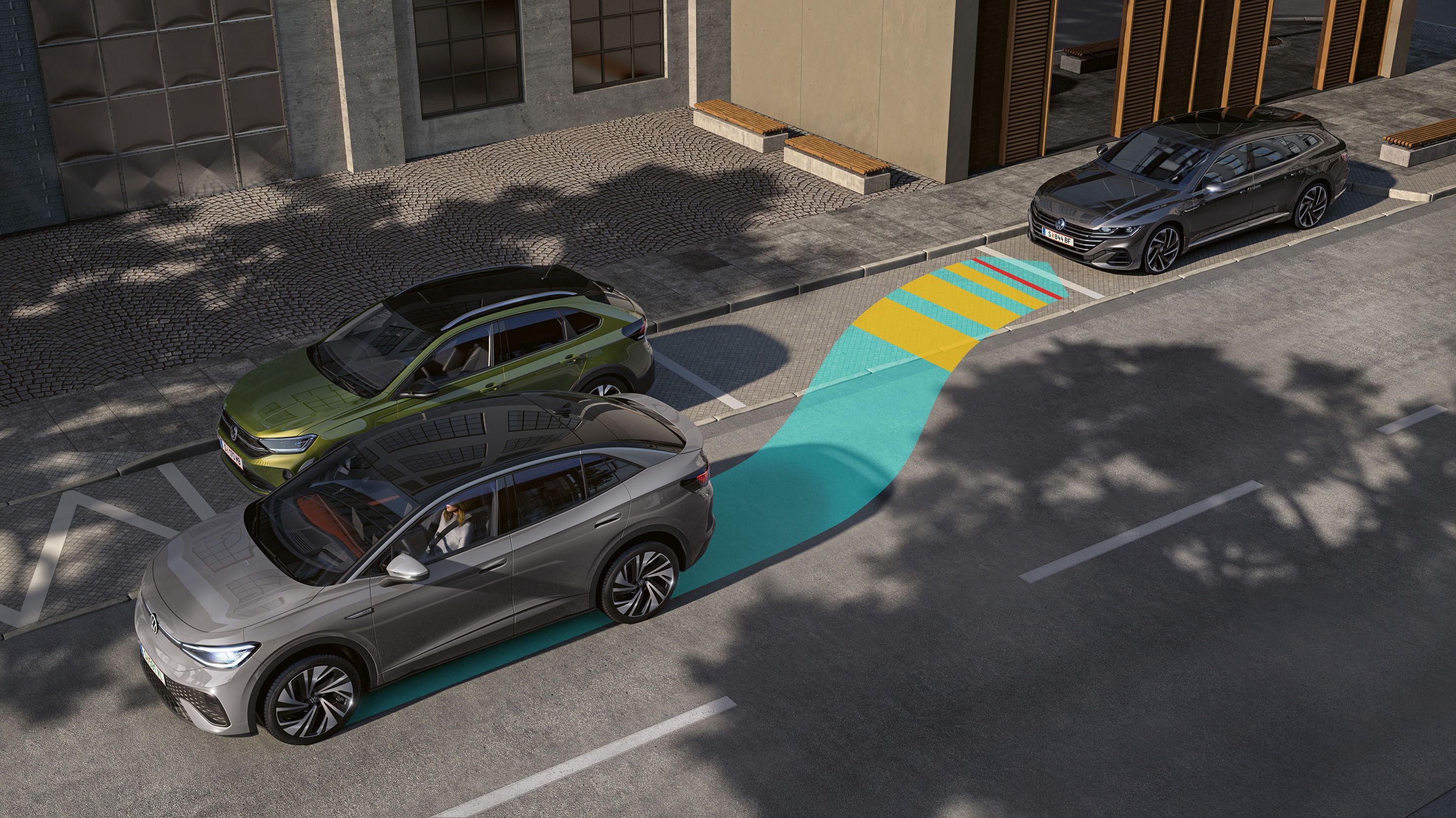 Automobil parkuje pozdĺž cesty medzi dvoma ďalšími autami. Graficky je znázornená dráha parkovania vozidla pomocou parkovacieho asistenta. Parkovacie miesta sú vedľa chodníka pri mestskej budove.