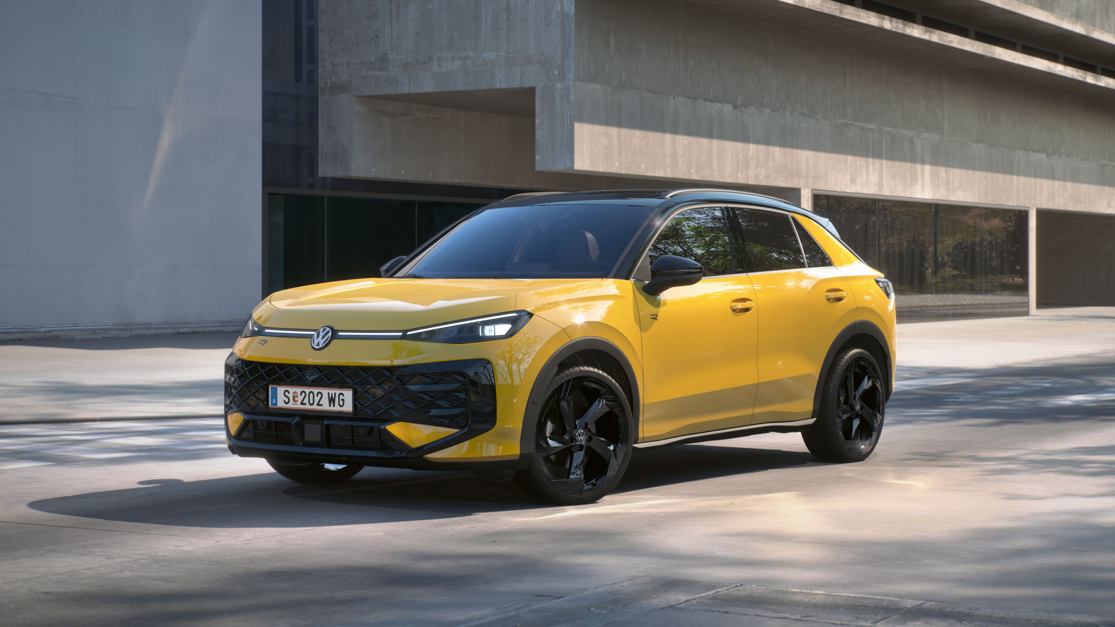 Žltý Volkswagen T-Roc R-Line stojí pred budovou.