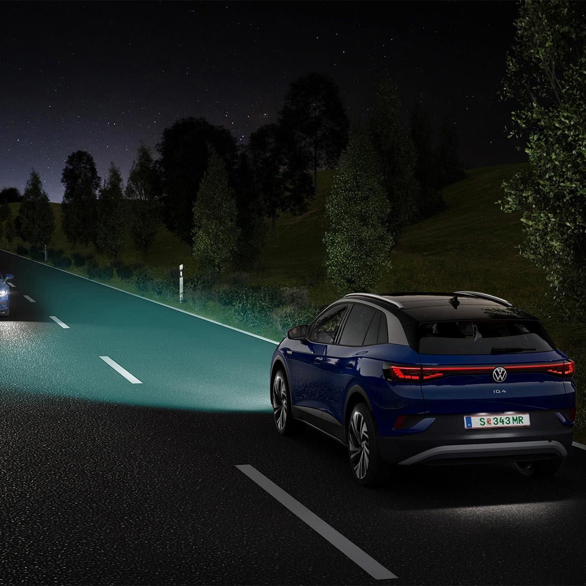 Modrý VW ID.4 jazdí po nočnej ulici so zapnutými svetlami.