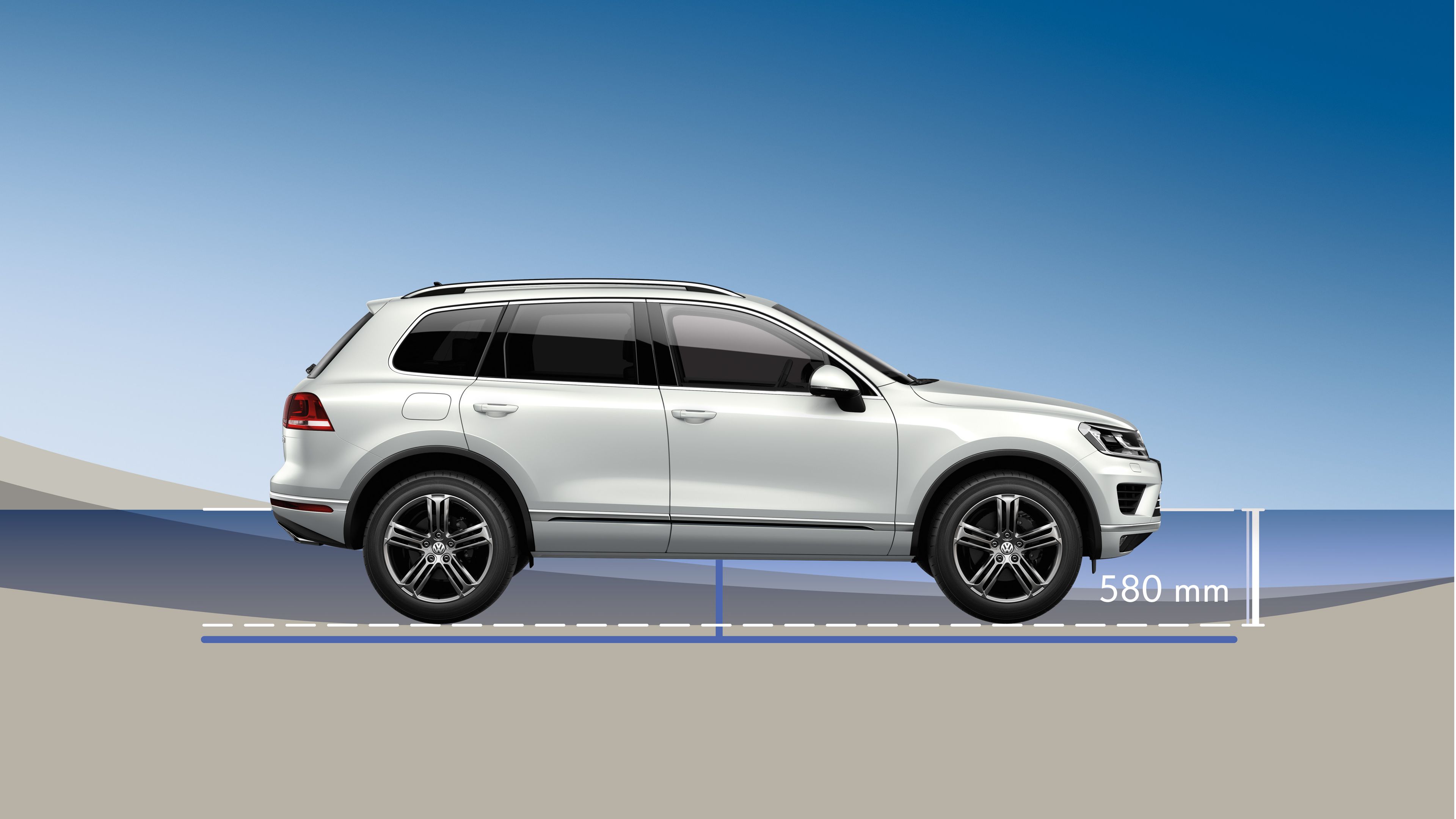 Graficky zobrazené svetlé SUV zboku na pozadí s modrou oblohou. Pod autom je odmeraná výška 580 mm od dna. Obrázok znázorňuje brodivosť vozidla. Auto je zaparkované na rovnej ploche.