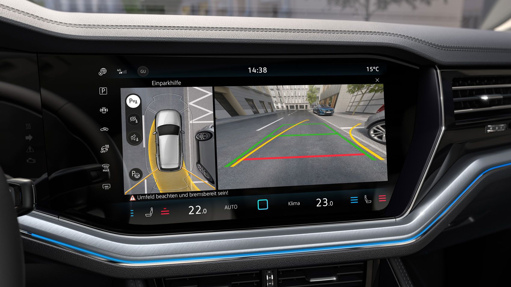 Dotykový displej systému infotainment zobrazujúci obraz z cúvacej kamery. Na ľavej strane je zobrazený pohľad zhora na zaparkované auto. Na pravej strane sú farebné línie, ktoré pomáhajú vodičovi pri parkovaní.