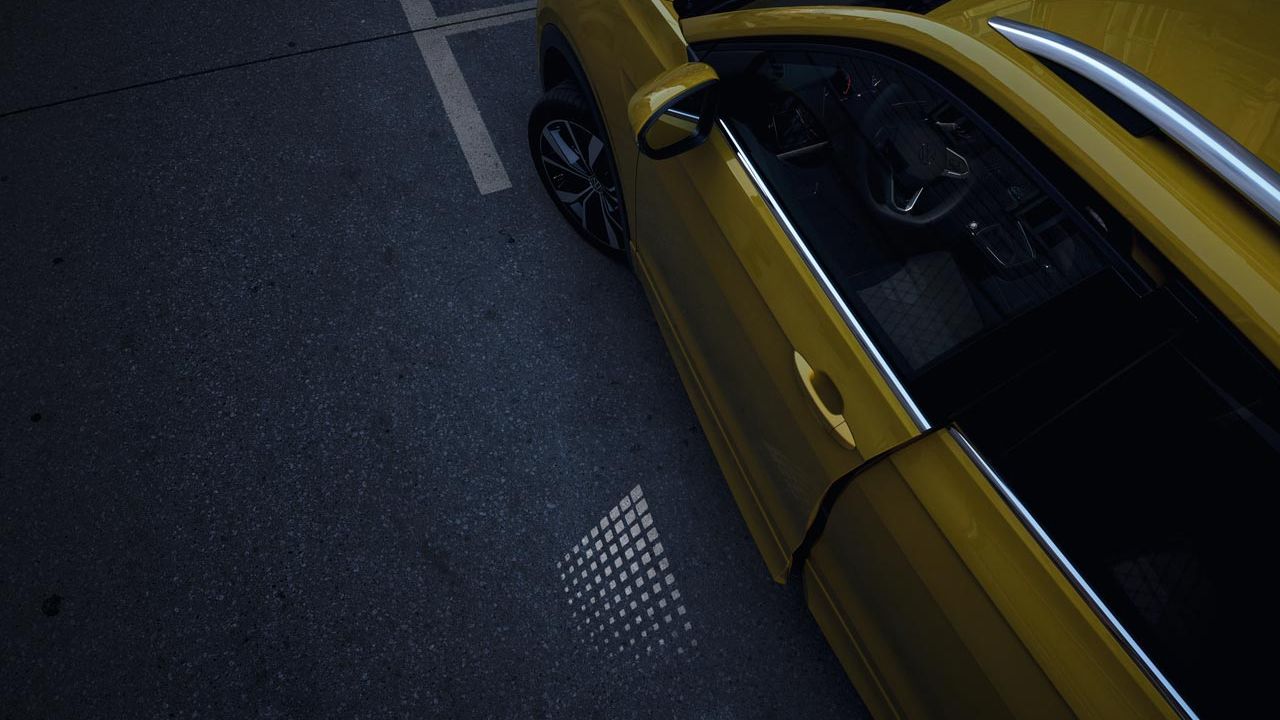 Dvere vodiča zhora, otvorené iba na štrbinu, s viditeľným svetlom premietajúcim sa v šere na cestu.