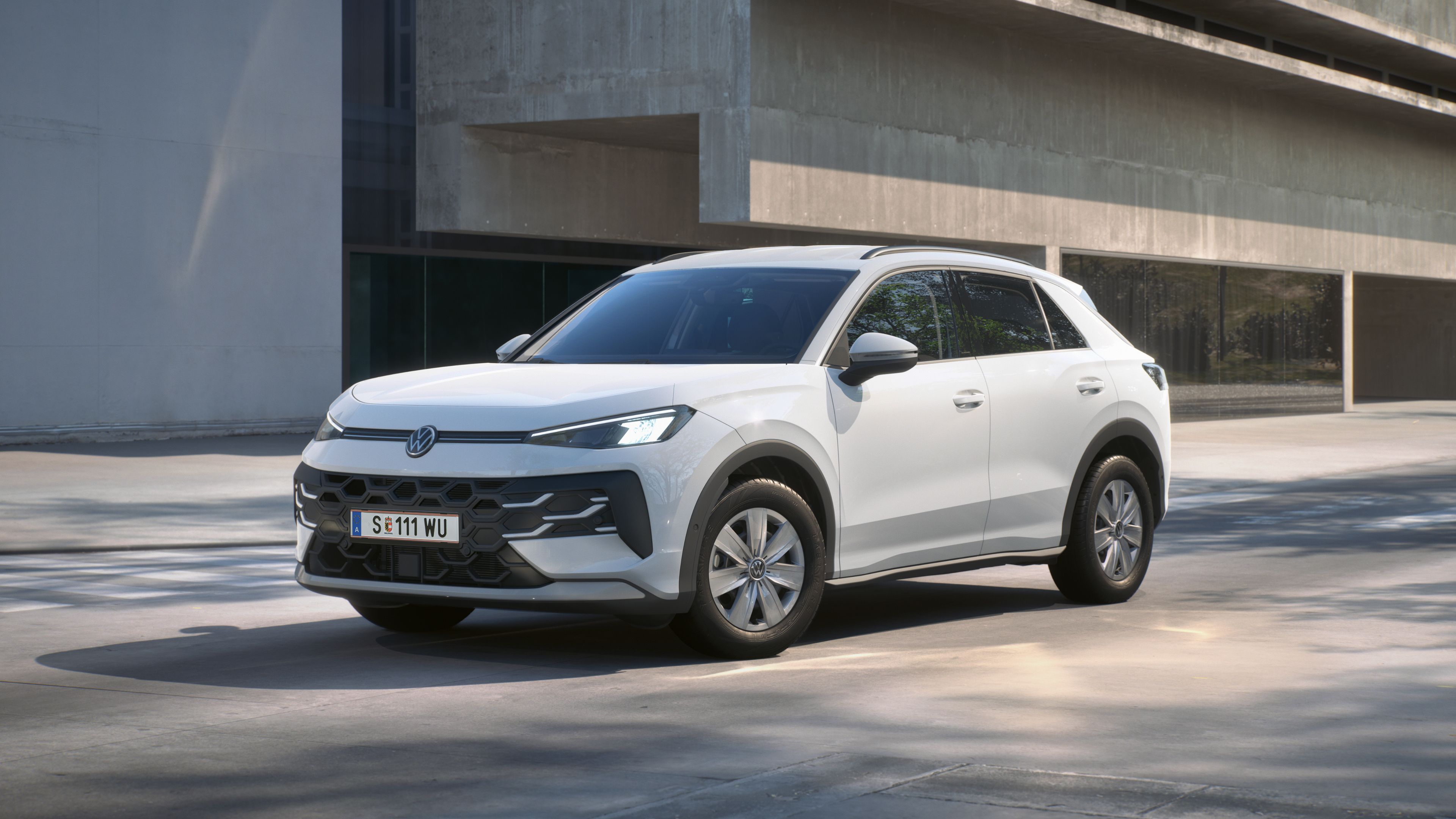 Biely Volkswagen T-Roc R Trend stojí pred budovou.