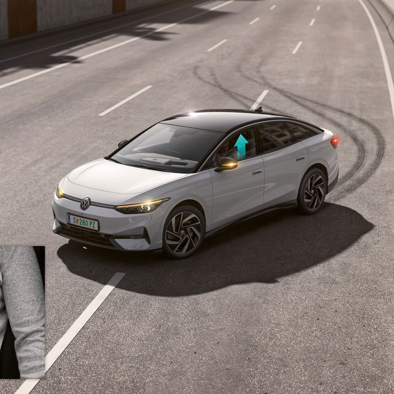 Volkswagen stojí na diaľnici a za vozidlom sú viditeľné brzdné stopy pneumatík. V spodnom ľavom rohu je detail na zapnutý bezpečnostný pás, na ktorom šípky naznačujú pritiahnutie v prípade kritickej situácie. Vozidlo má čiernu sklenenú panoramatickú strechu a moderný dizajn.