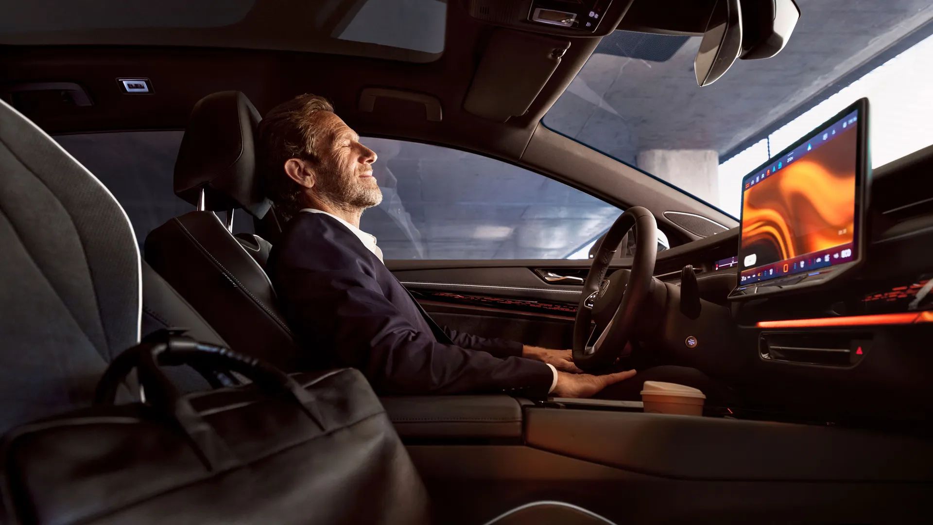 Muž sedí vo svojom vozidle Volkswagen, má zatvorené oči a používa aplikáciu Wellness.