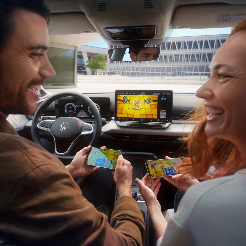 Pár vo VW T-Roc Style hrá Uno cez AirConsole so smartfónmi ako ovládačmi.