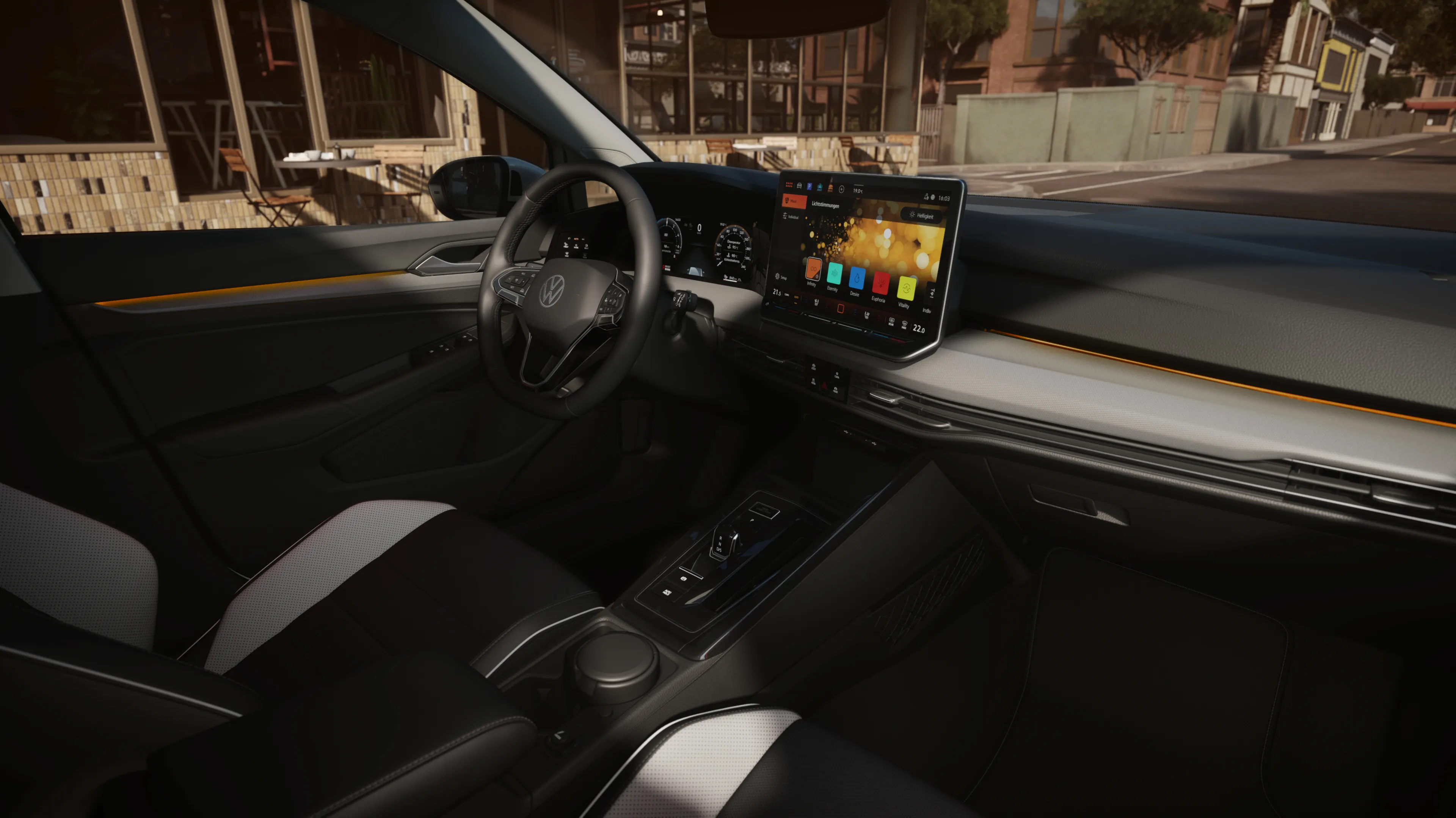 Pohľad do interiéru vozidla s dotykovým displejom na palubnej doske, svetlým a tmavým čalúnením sedadiel. Volant disponuje ovládacími funkciami. Cez okno vidieť ulicu.