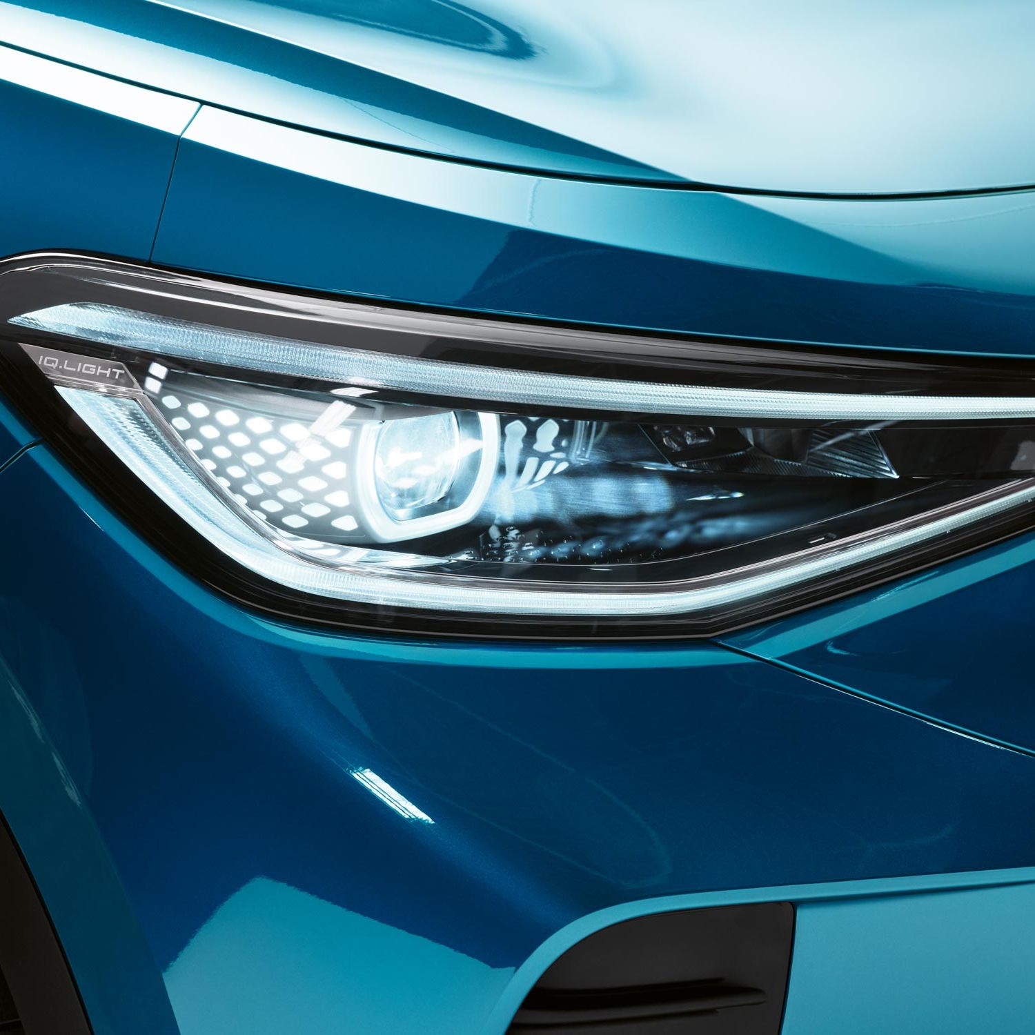 Detailný pohľad na Matrix LED svetlomety vo VW ID.4. Čiastočne vidieť predný nárazník a kapotu vozidla.