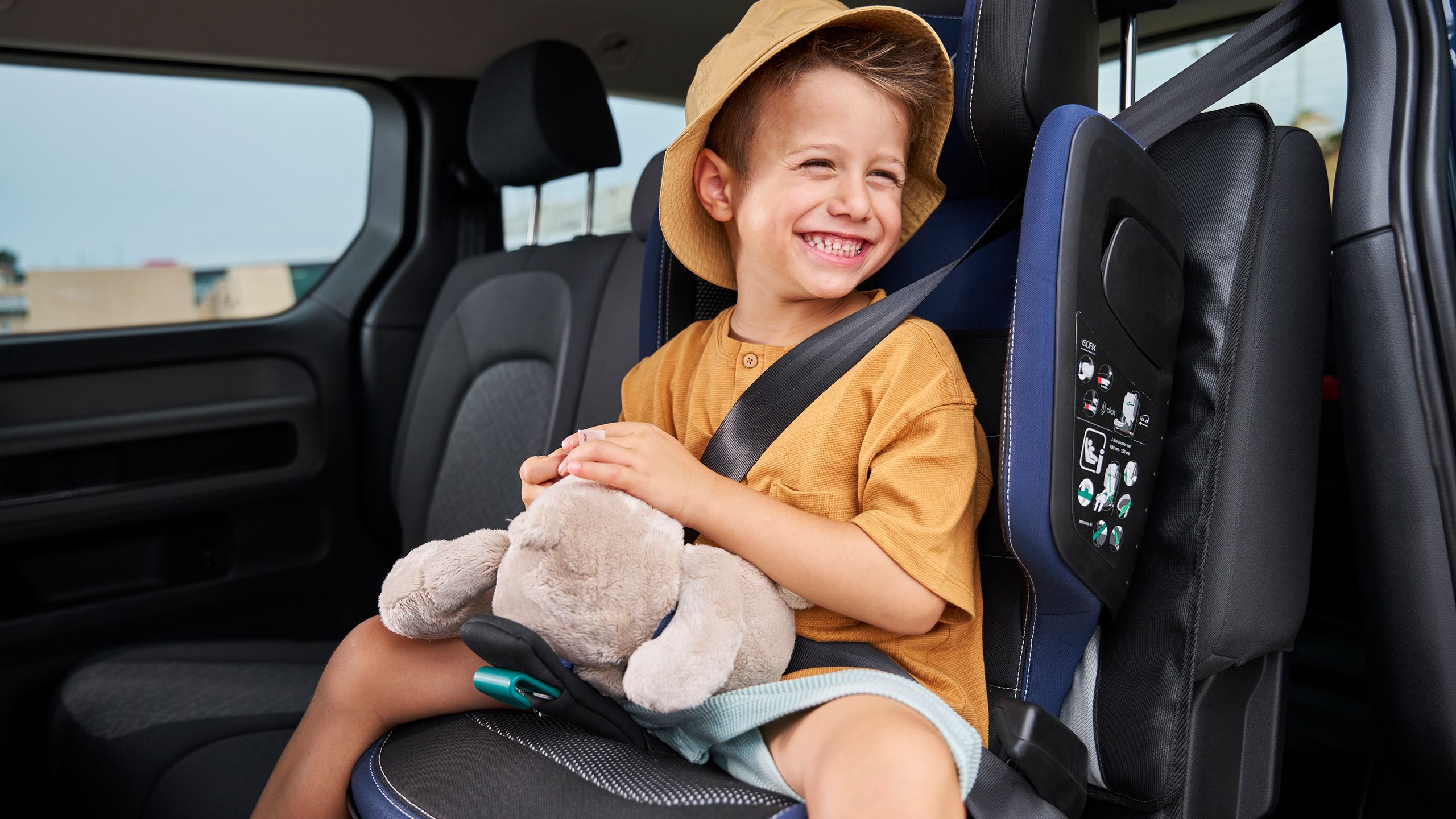 Dieťa s plyšovou hračkou v detskej sedačke z príslušenstva VW