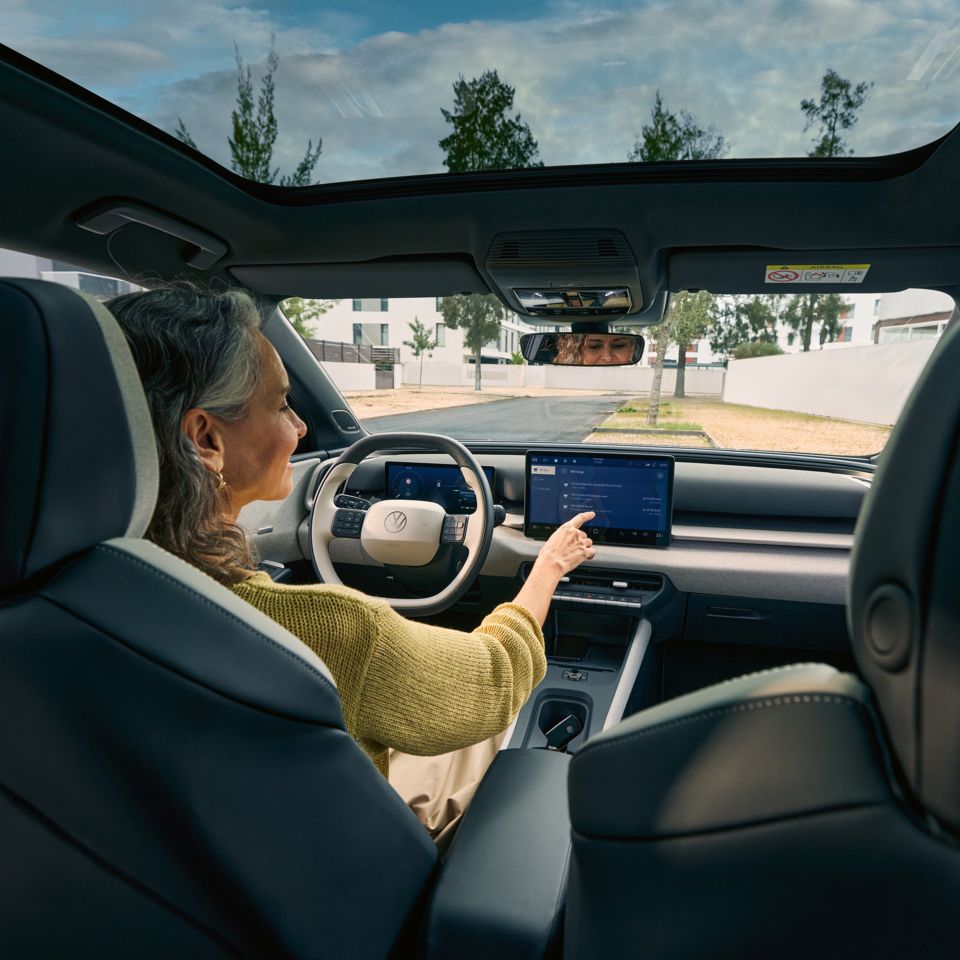 Žena sedí za volantom VW ID. Cross a ovláda infotainment systém.
