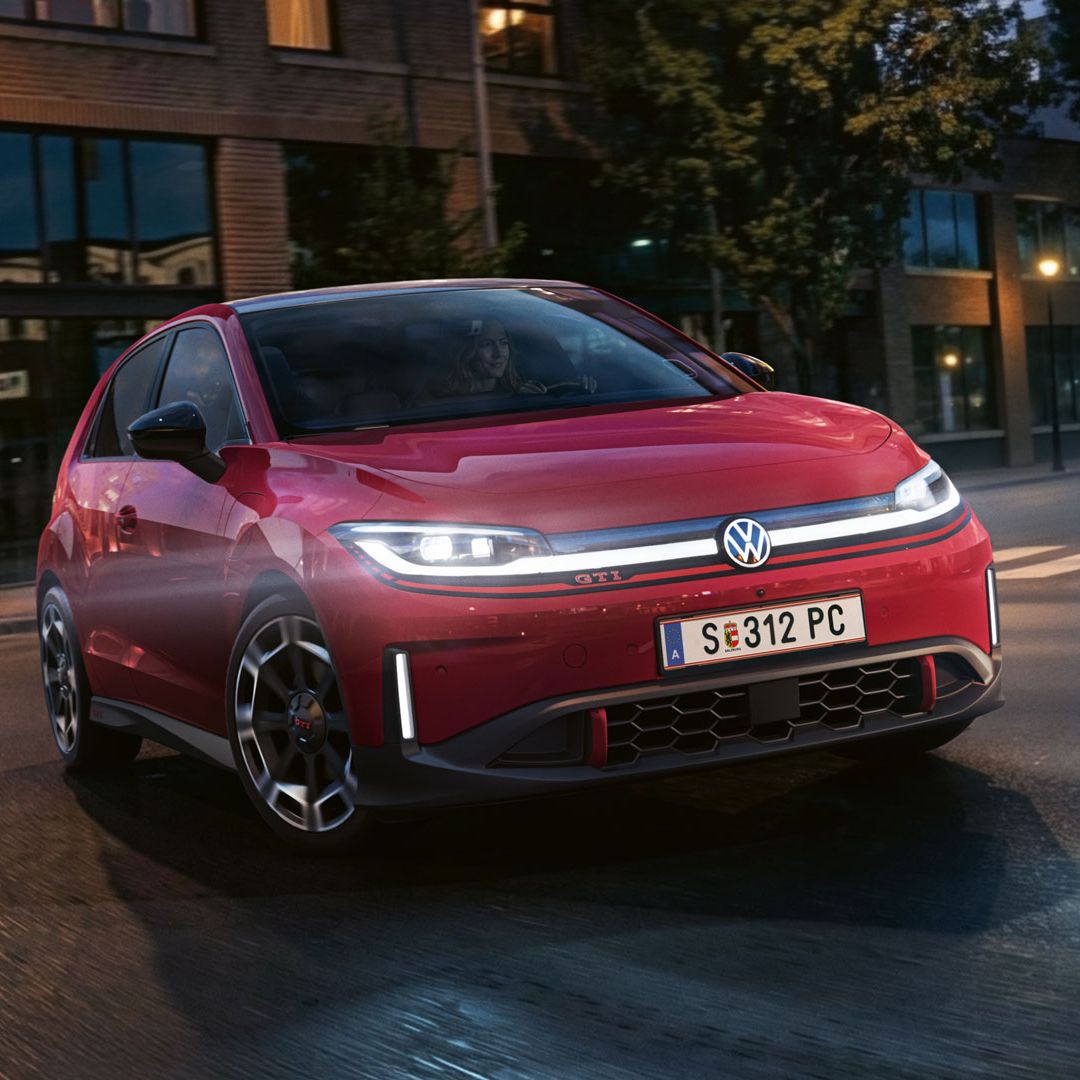 Červený VW ID. Polo GTI odbočuje na križovatke pri večernom svetle.