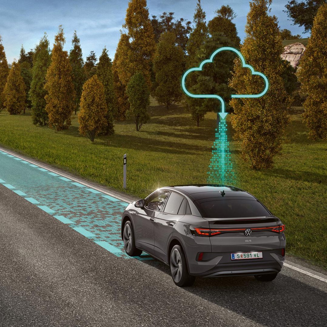 Dve vozidlá jazdia po ceste, ktorú lemuje zeleň a stromy. Grafika zobrazuje fungovanie systému Connected Travel Assist.