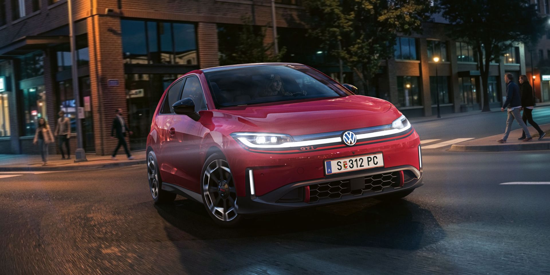 Červený VW ID. Polo GTI odbočuje na križovatke pri večernom svetle.