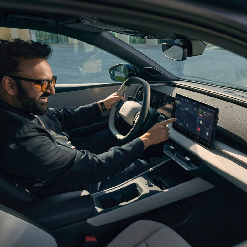 Muž sedí vo VW ID. Cross a ovláda infotainment systém.