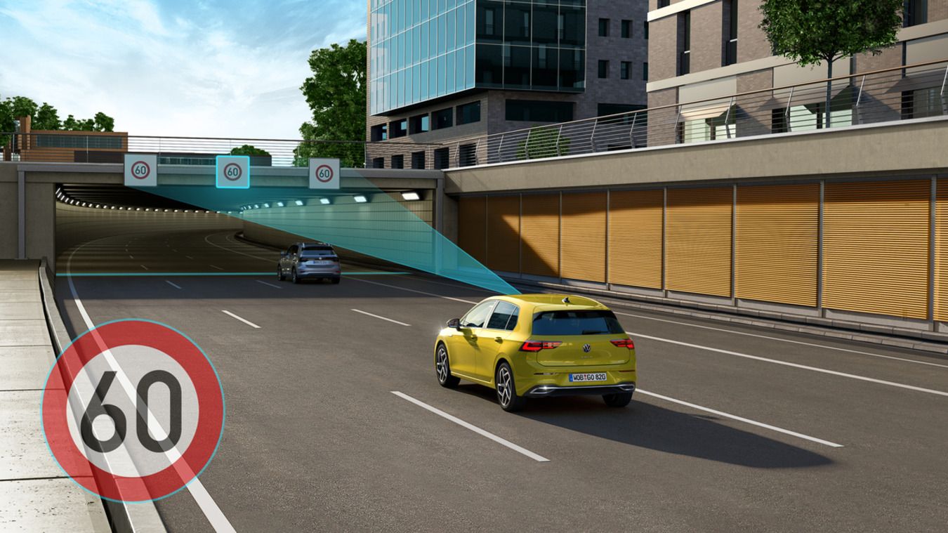 Animovaný obrázok, ktorý znázorňuje žltý Volkswagen Golf zozadu, ako jazdí po diaľnici a deteguje dopravnú značku pred sebou.