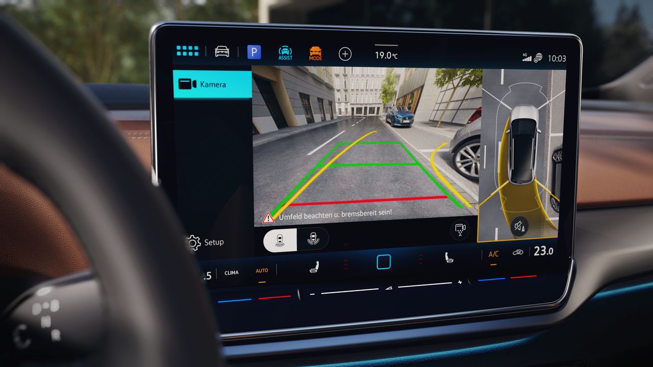 Displej systému infotainment integrovaný v palubnej doske, ktorý zobrazuje pohľad zadnej kamery na okolie za vozidlom. Na displeji sú vyznačené farebné línie na lepšiu orientáciu pri cúvaní. Po pravej strane sa nachádza aj bočný diagram auta so senzorovými údajmi.