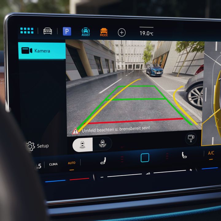 Displej systému infotainment integrovaný v palubnej doske, ktorý zobrazuje pohľad zadnej kamery na okolie za vozidlom. Na displeji sú vyznačené farebné línie na lepšiu orientáciu pri cúvaní. Po pravej strane sa nachádza aj bočný diagram auta so senzorovými údajmi.