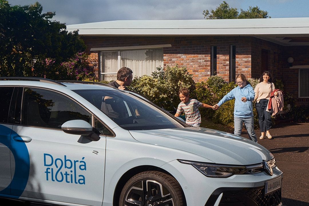 Rodina s dvomi väčšími deťmi ide z domu k svojmu vozidlu Volkswagen.