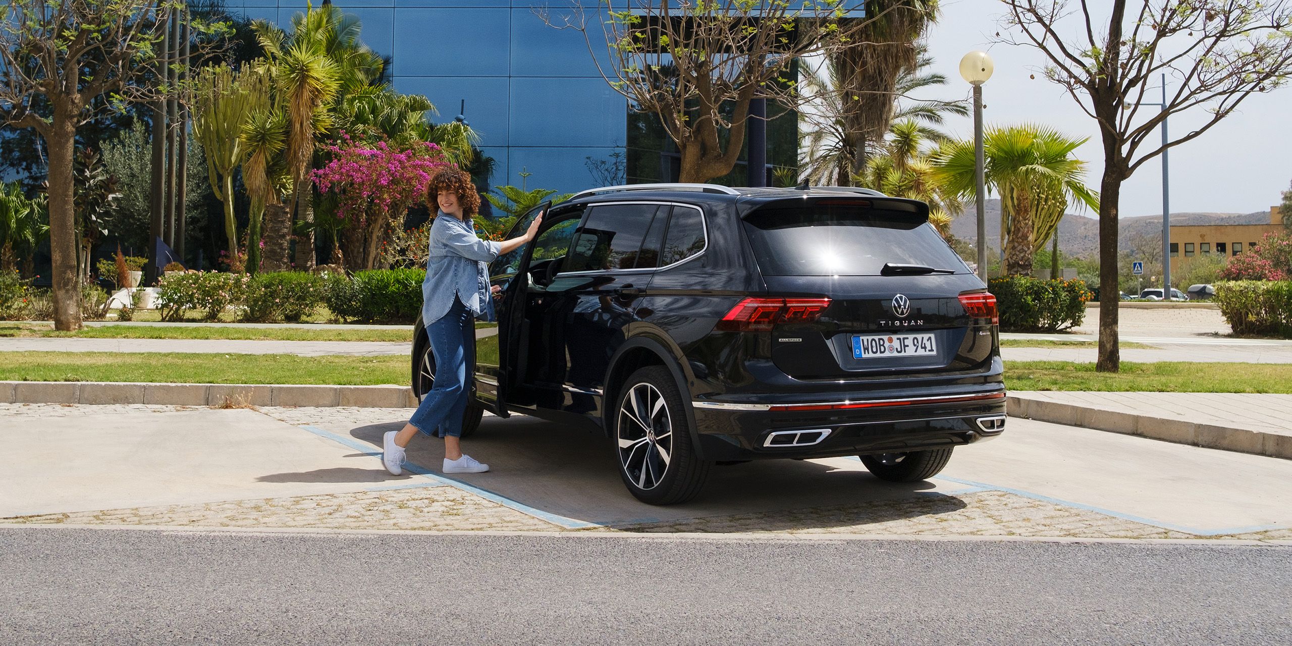 Žena otvára dvere vodiča na vozidle VW Tiguan Allspace
