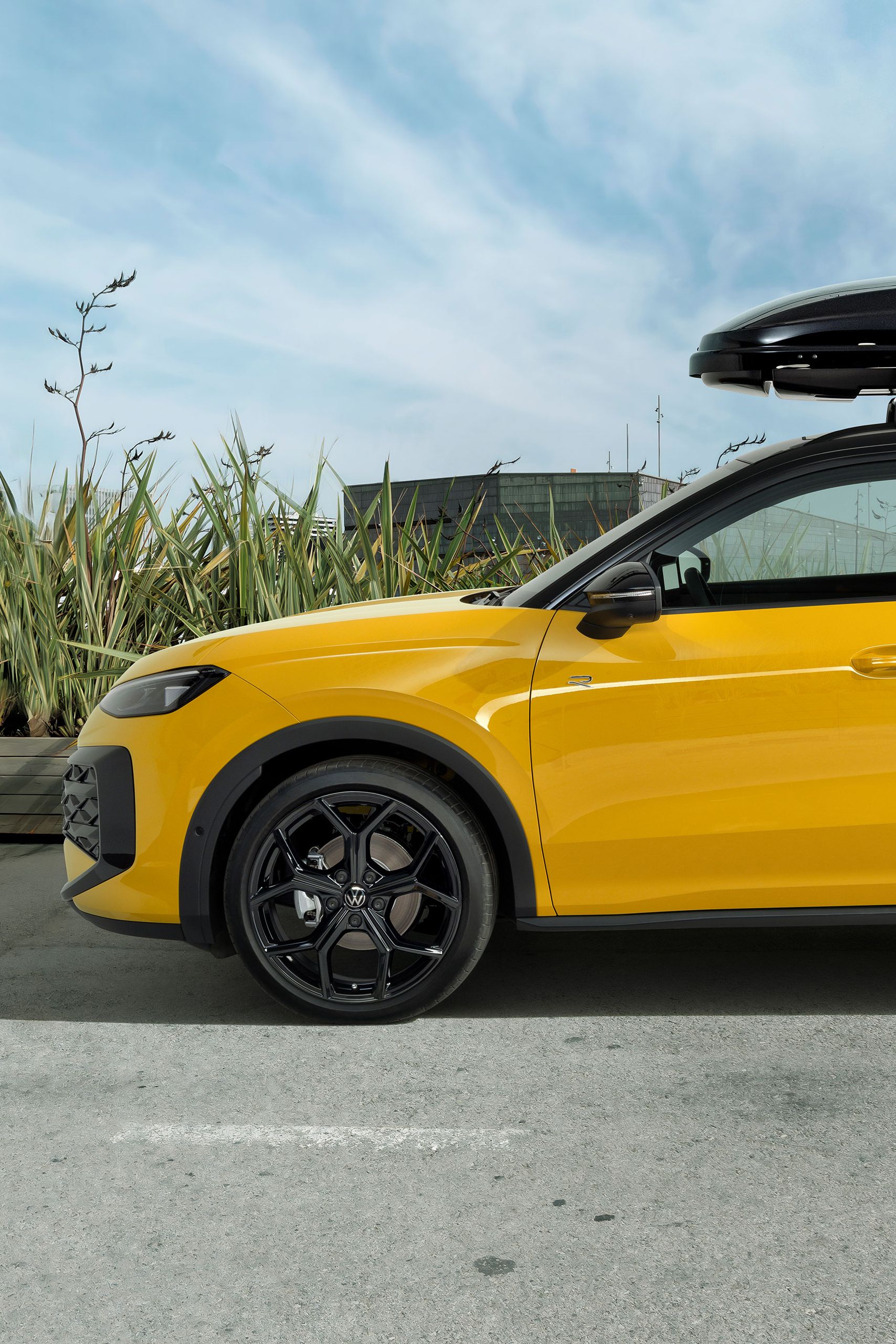 Žltý VW T-Roc so strešným boxom zaparkovaný na ceste – príslušenstvo T-Roc