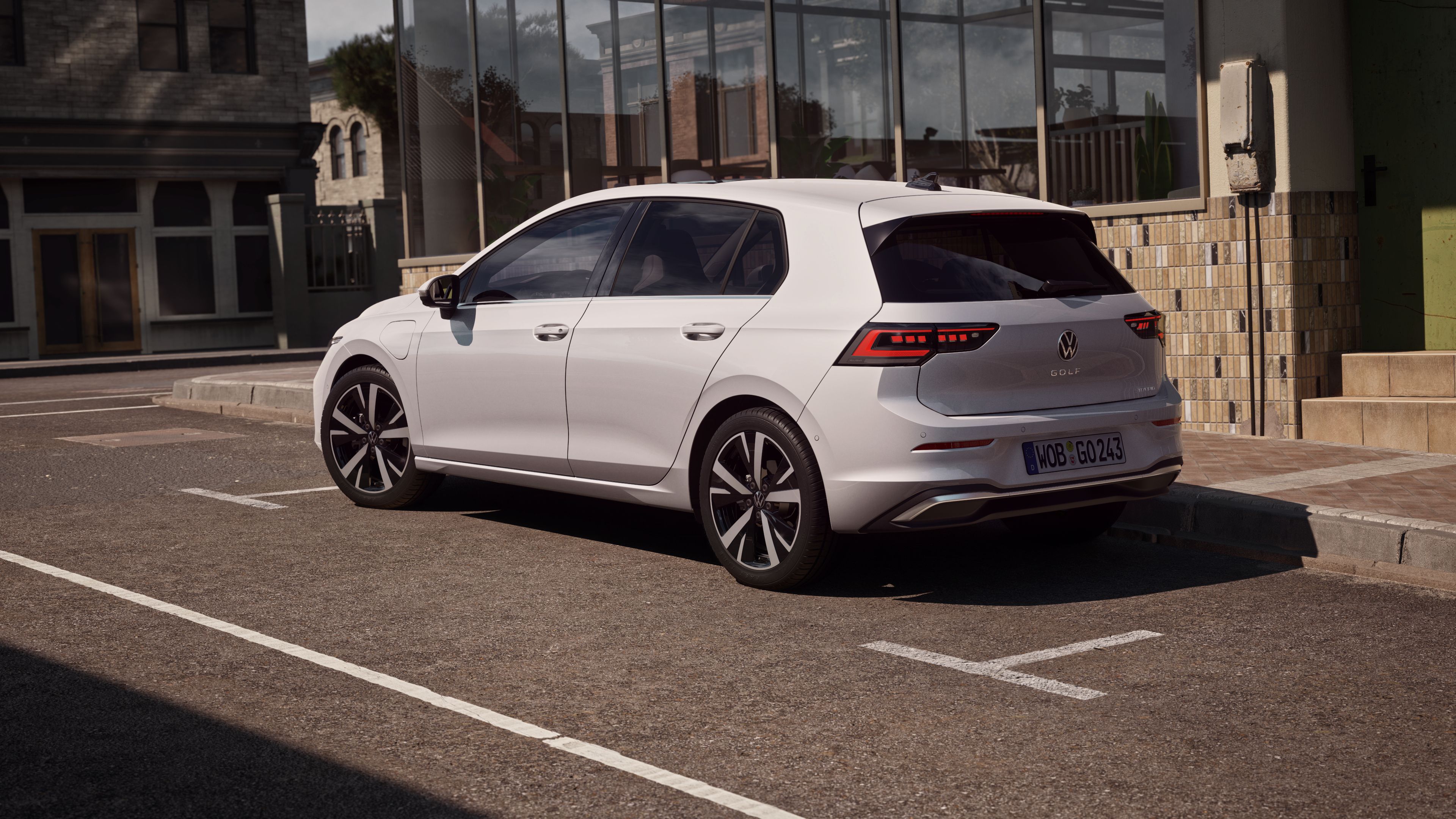Bočný pohľad na biely VW Golf zaparkovaný vedľa reštaurácie 
