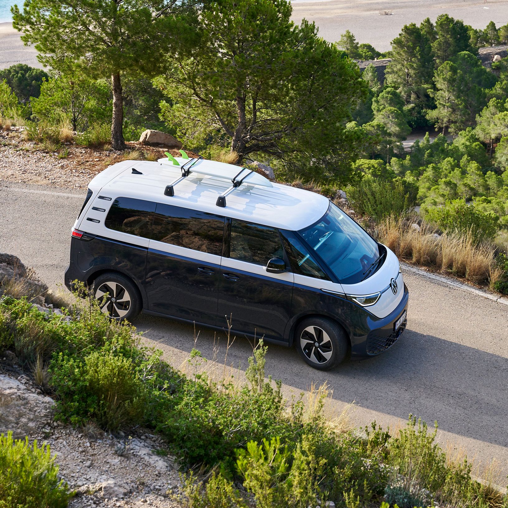 VW ID. Buzz so surfom na streche prechádza zákrutou