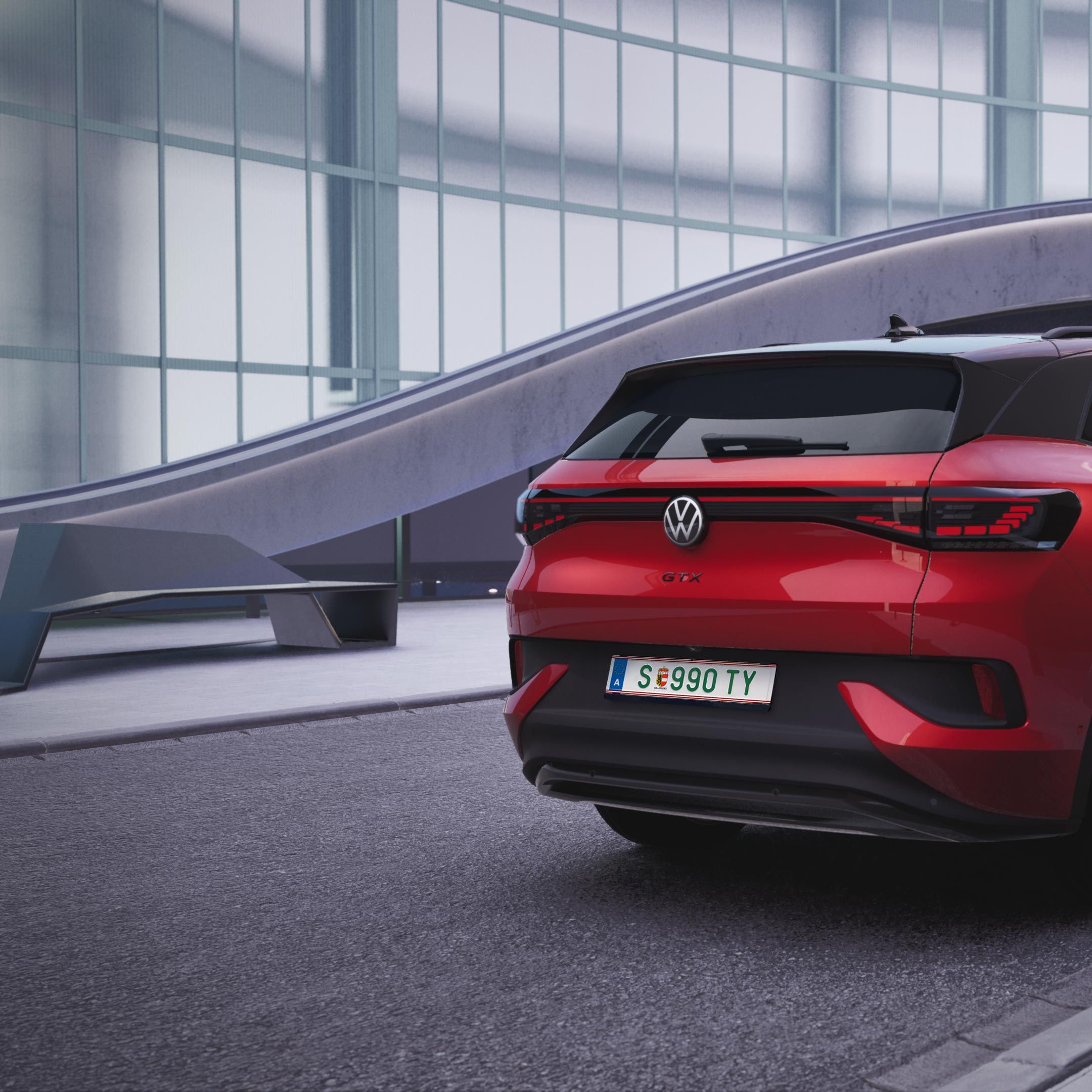 Červené SUV Volkswagen ID.4 GTX zaparkované pred modernou budovou so sklenenou fasádou. Automobil má čiernu sklenenú strechu a čierne disky kolies. V pozadí je futuristická architektúra.