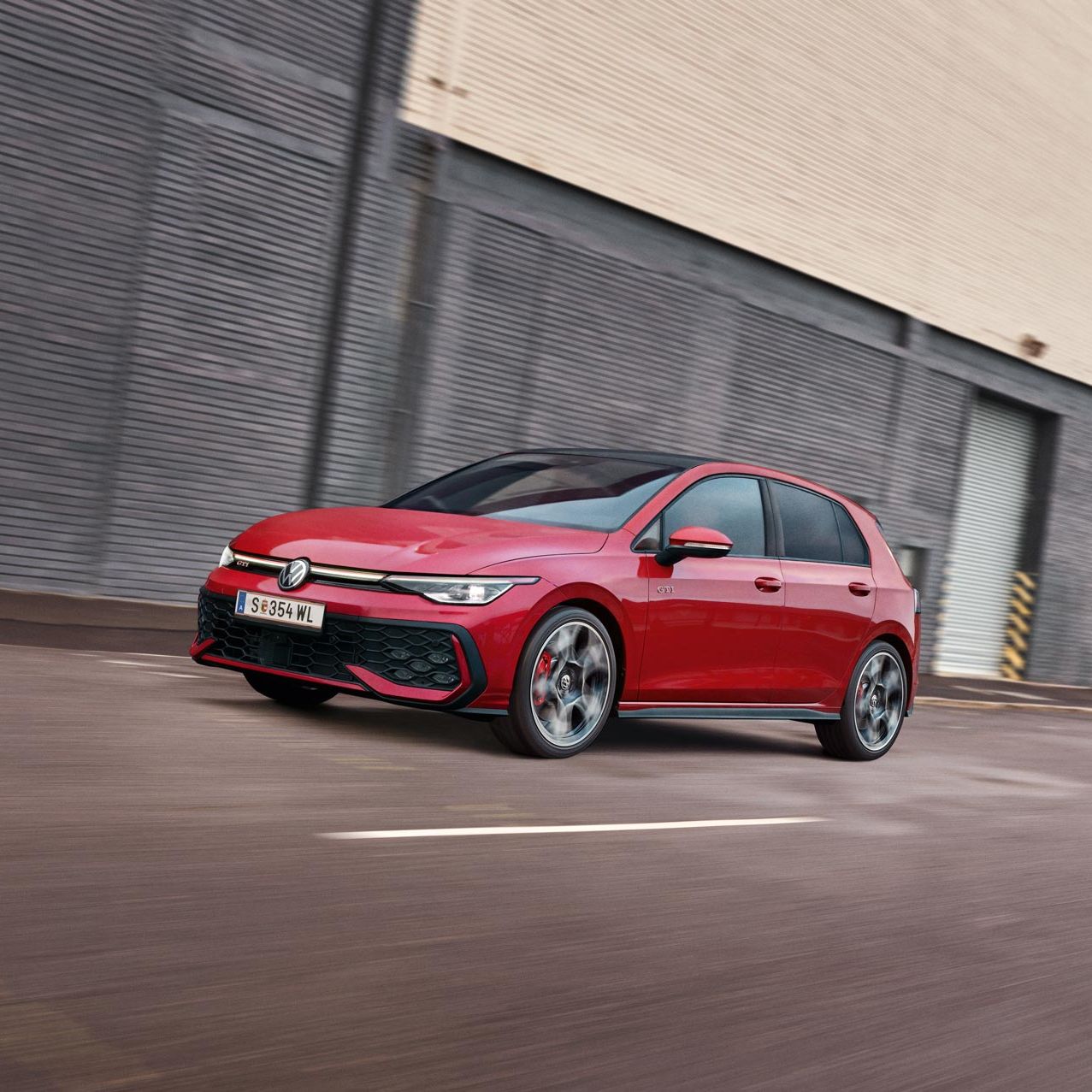 Pohľad spredu na červený Golf GTI, ktorý jazdí v meste.