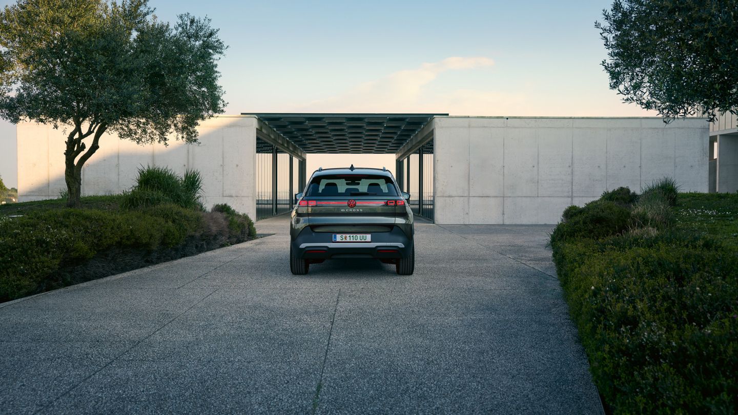 Pohľad zozadu na vozidlo VW ID. Cross, ktoré parkuje pred bielou budovou.