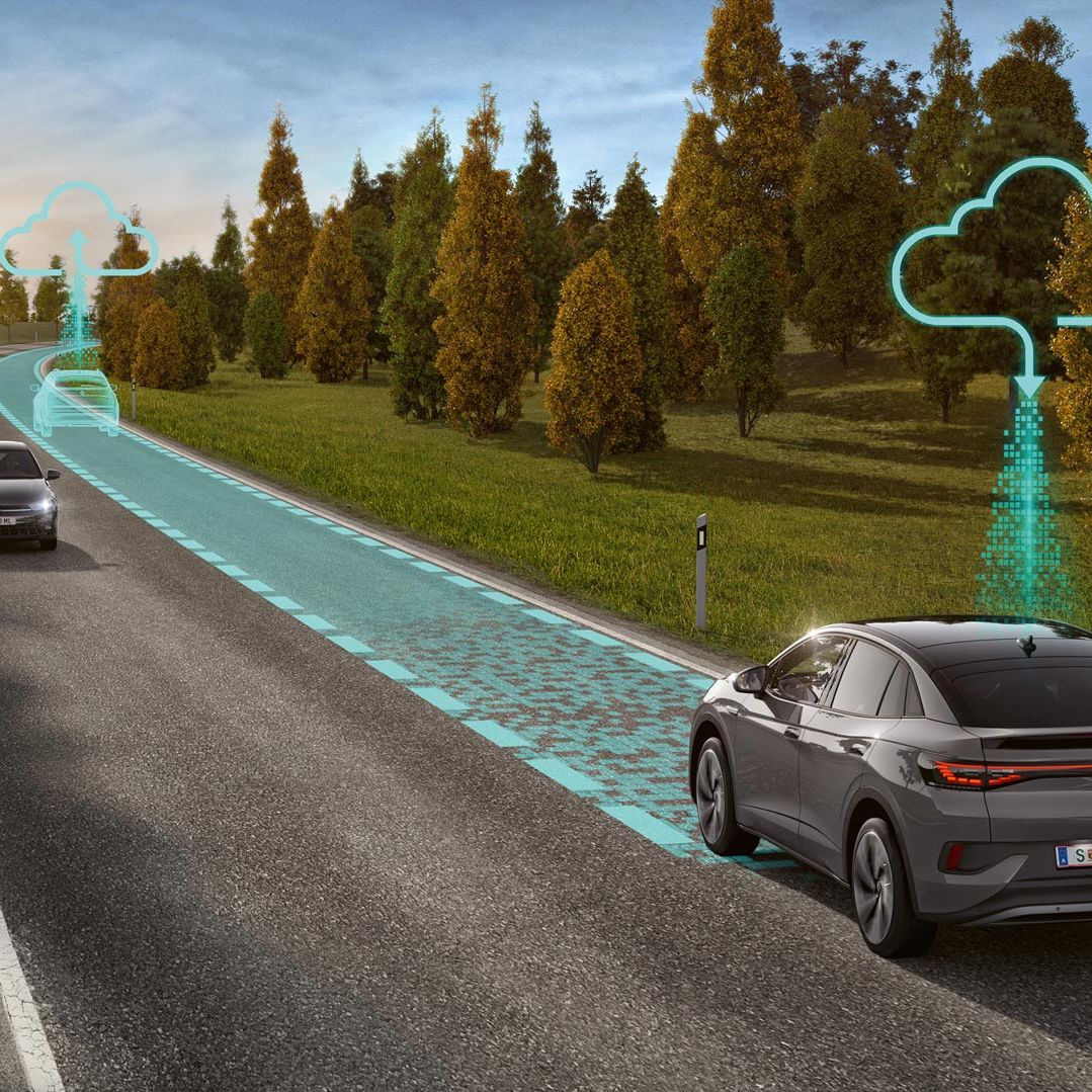 Dve vozidlá jazdia po ceste, ktorú lemuje zeleň a stromy. Grafika zobrazuje fungovanie systému Connected Travel Assist.