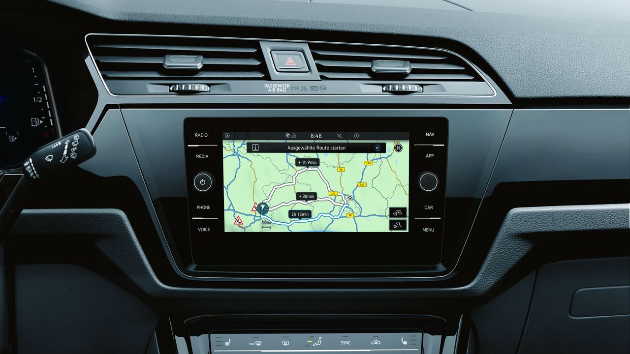 Pohľad na palubnú dosku automobilu s multimediálnym systémom. Na displeji je navigačná mapa. Pod ním je ovládanie klimatizácie.