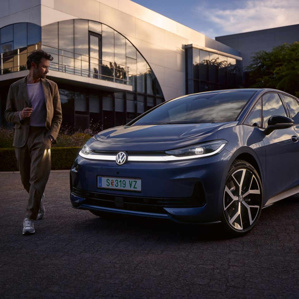 Muž obchádza prednú časť modrého VW ID.3 Neo a obdivuje dizajn osvetlenia