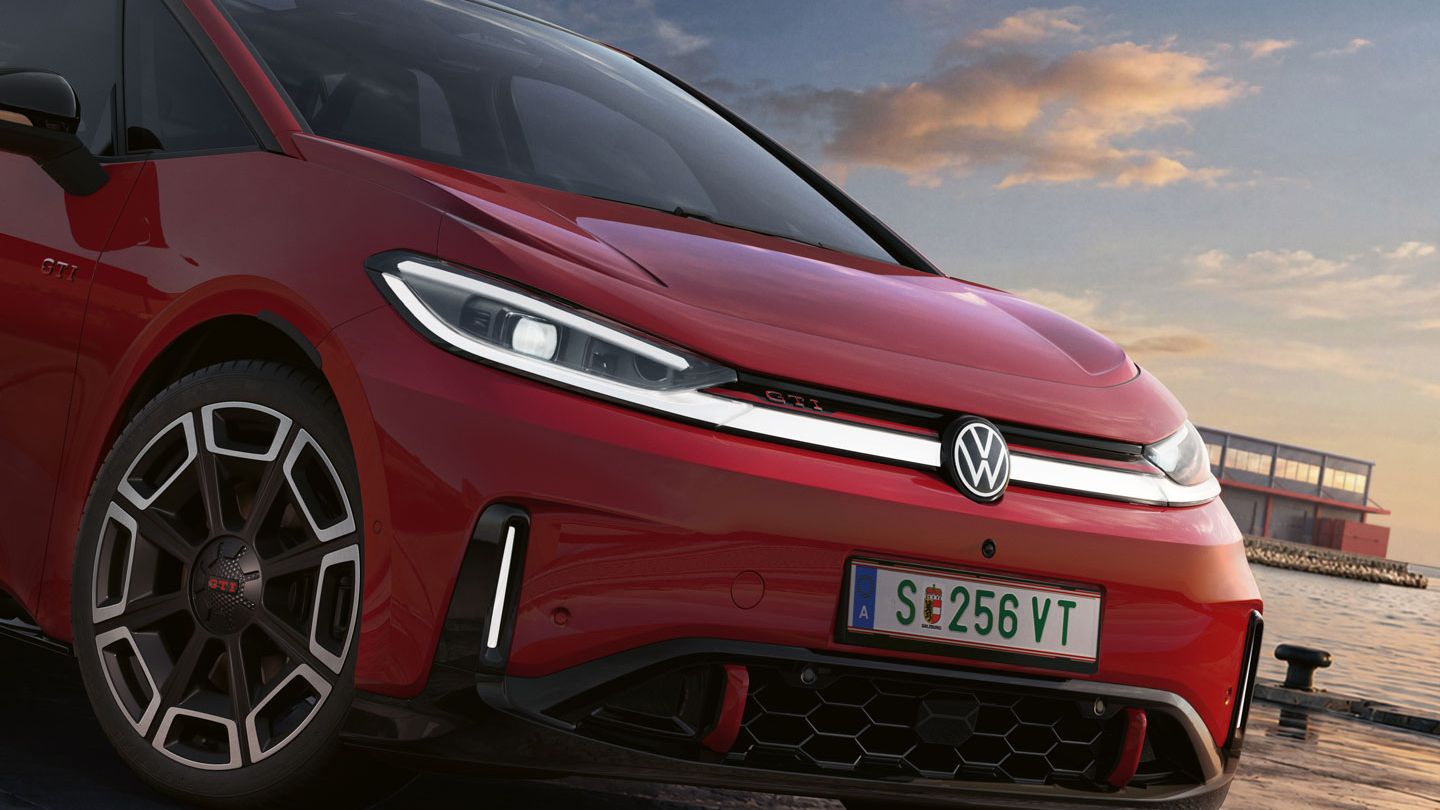 [AI-modified] – Detail predných partií zaparkovaného červeného VW ID.3 GTI so zapnutými svetlometmi a podsvieteným logom.