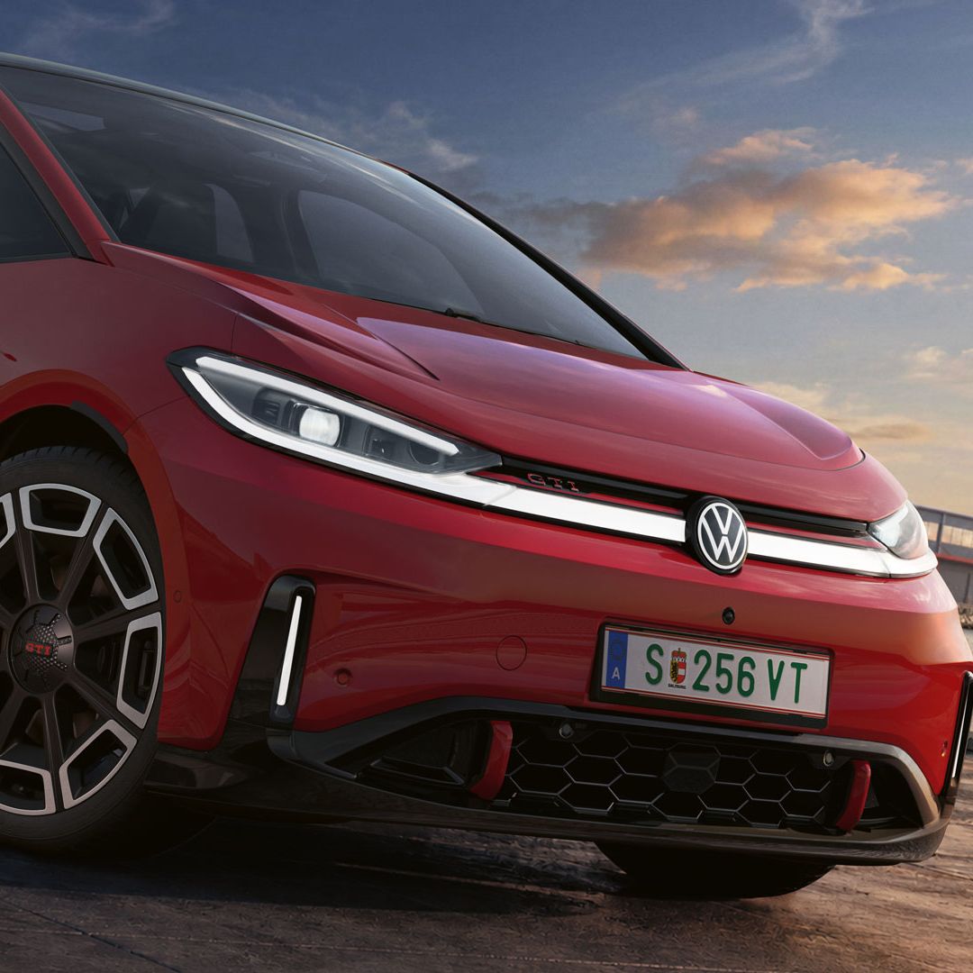 [AI-modified] – Detail predných partií zaparkovaného červeného VW ID.3 GTI so zapnutými svetlometmi a podsvieteným logom.