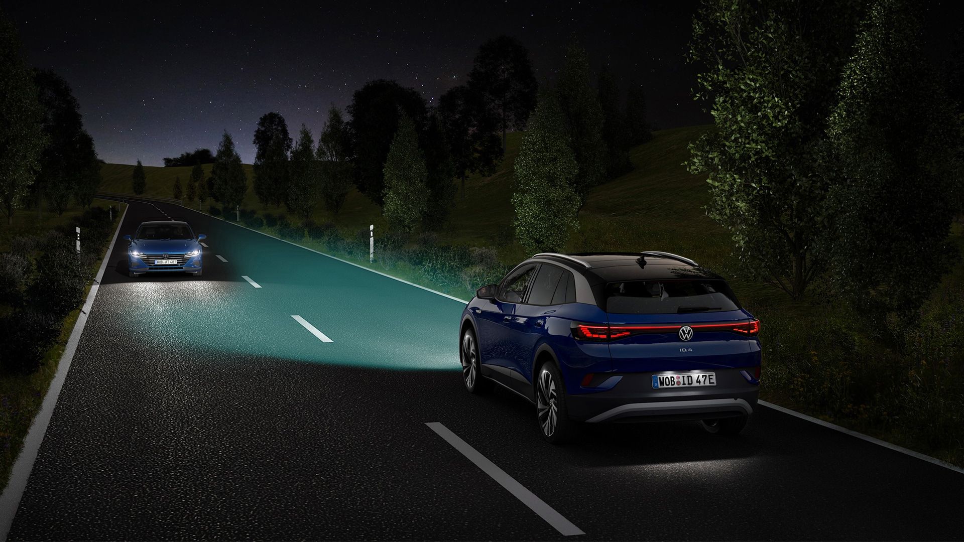 VW ID.4 jazdí v noci po vidieckej ceste, zvýraznené sú lúče svetlometov.