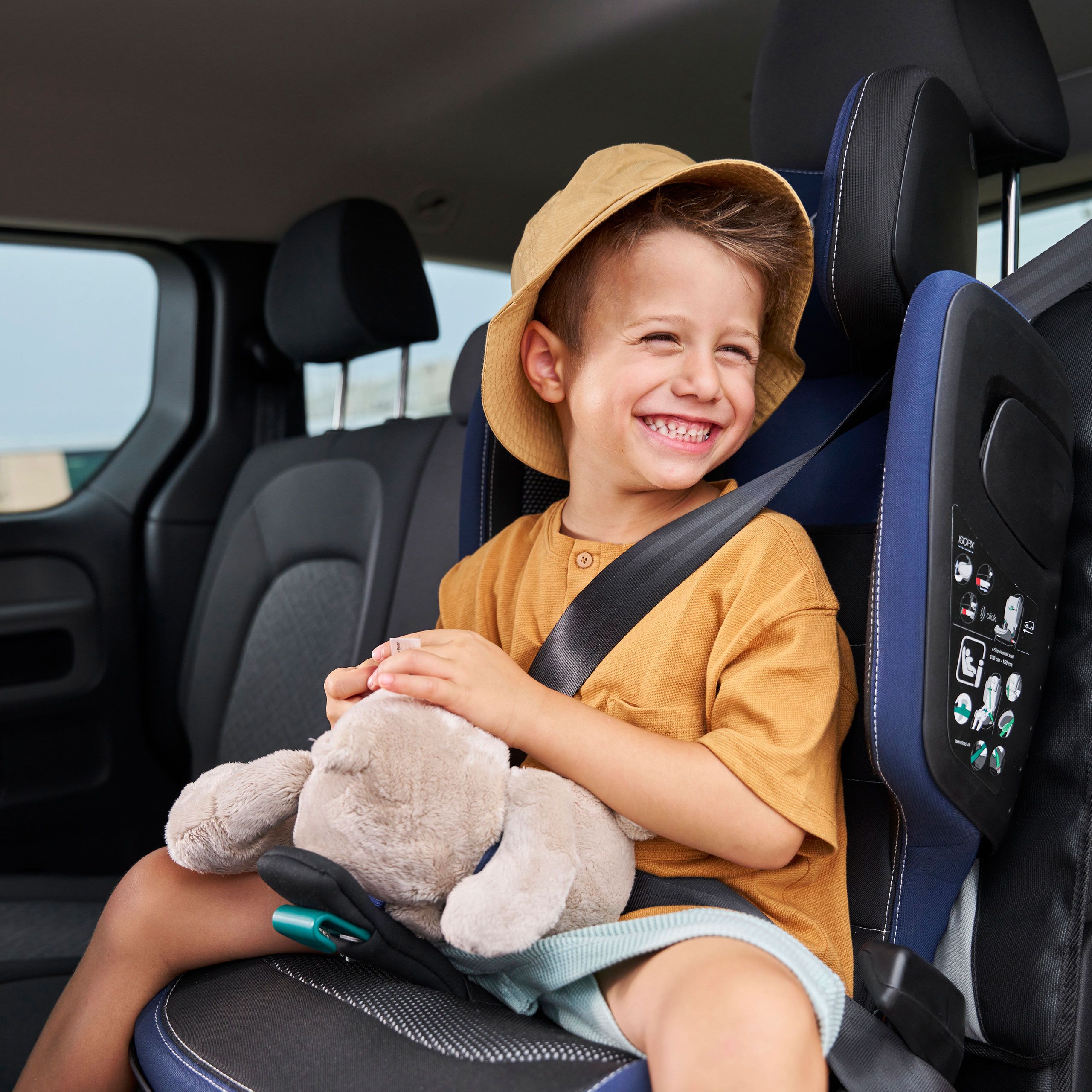 Dieťa s plyšovou hračkou v detskej sedačke z príslušenstva VW