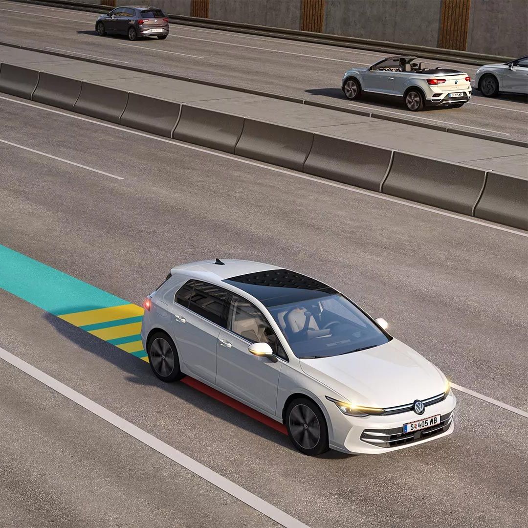 Biely VW Golf jazdí v premávke s aktívnym systémom Emergency Assist, schematicky znázornený na obrázku.