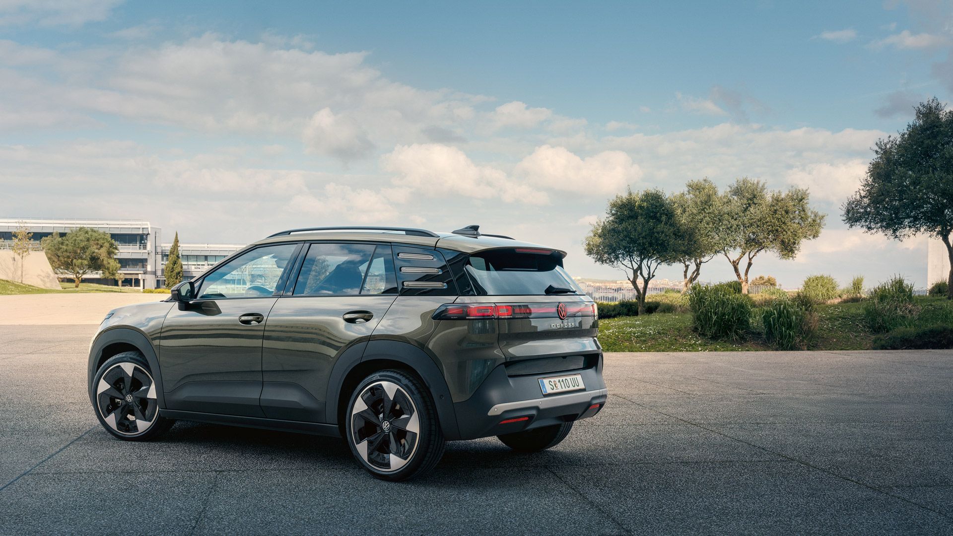 Pohľad zozadu na zelené VW ID. Cross zaparkované na námestí so zelenými stromami.