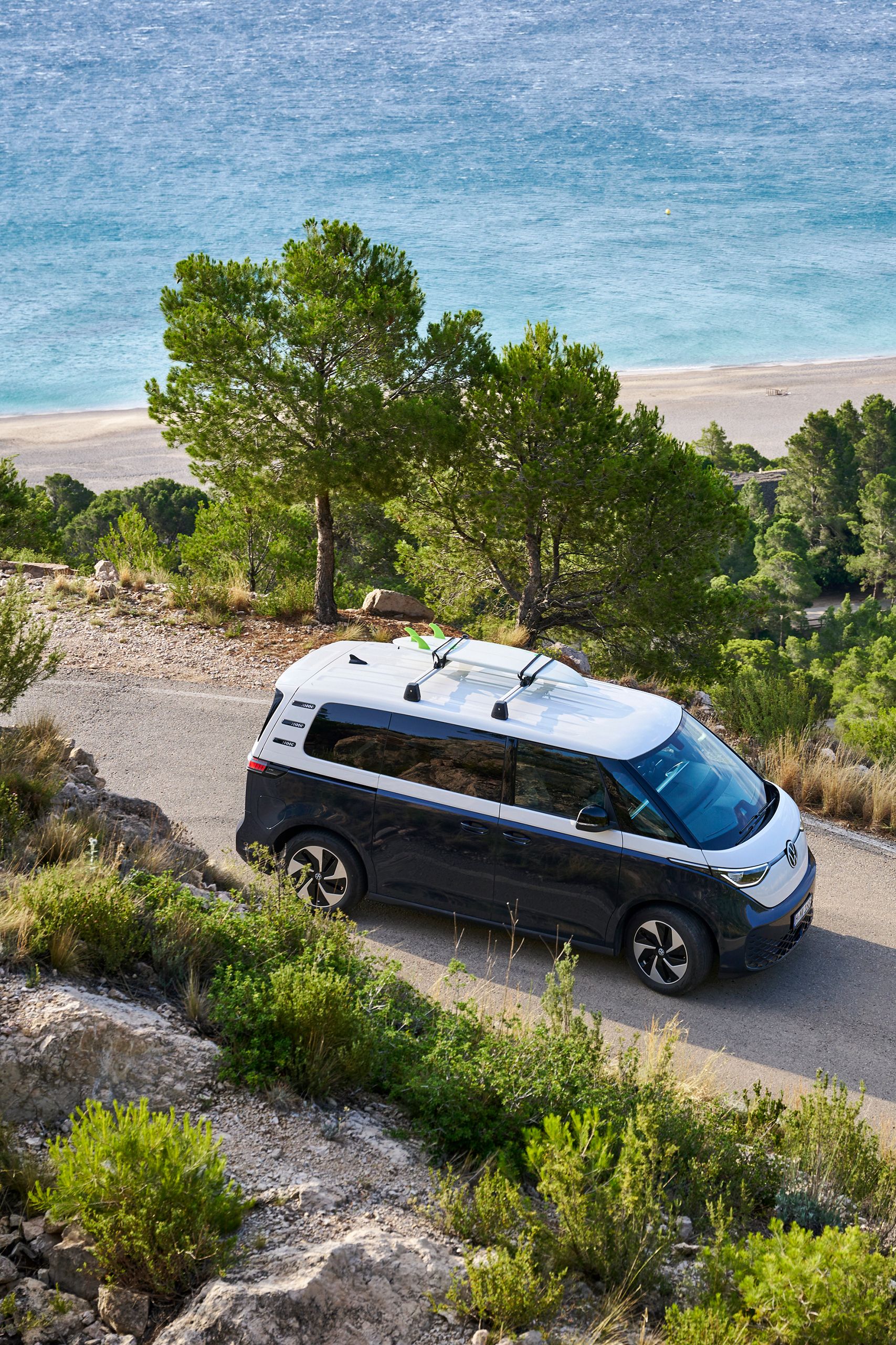 VW ID. Buzz so surfom na streche prechádza zákrutou