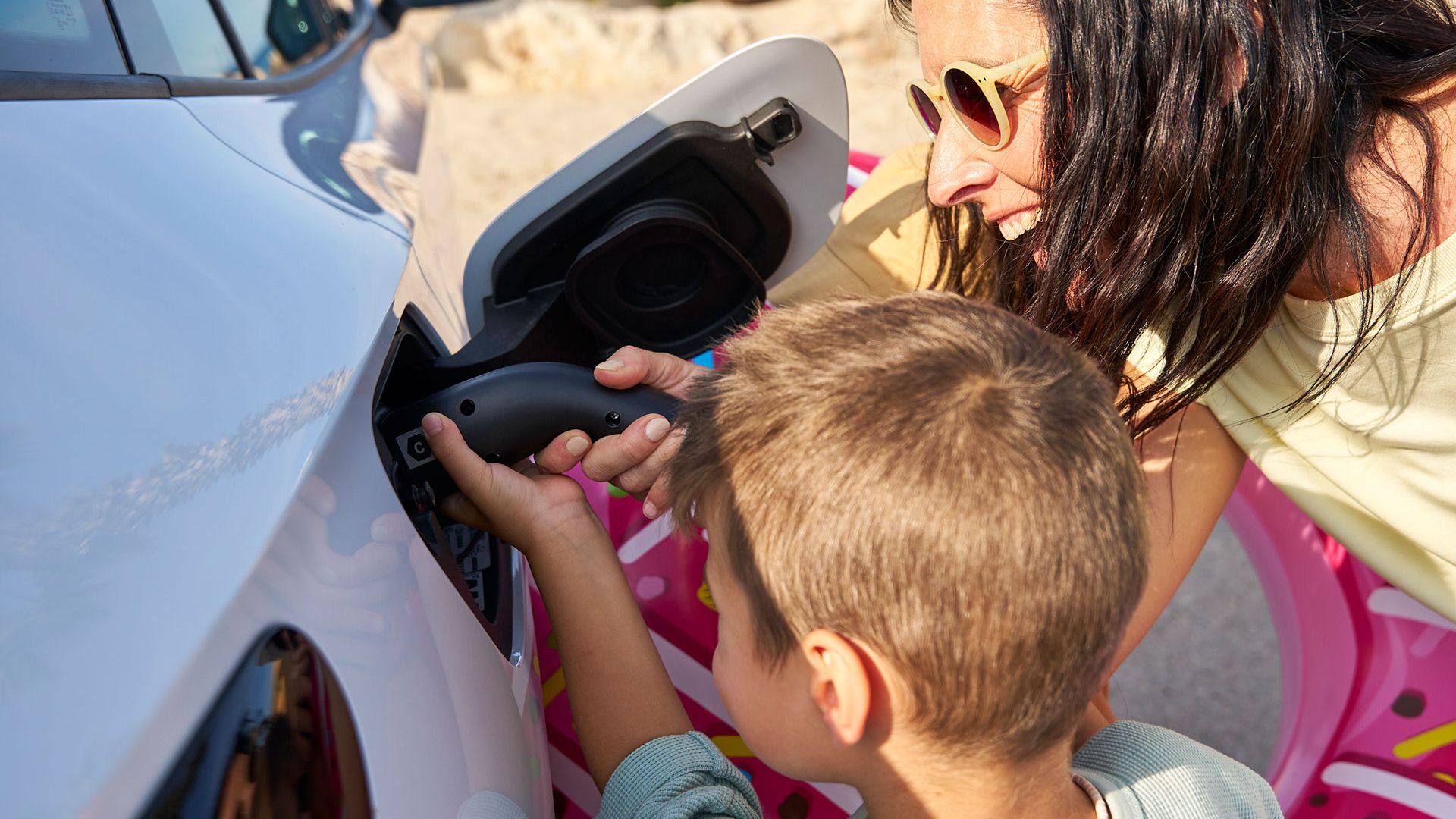 Matka a syn nabíjajú auto VW ID. nabíjacím káblom od VW Accessories