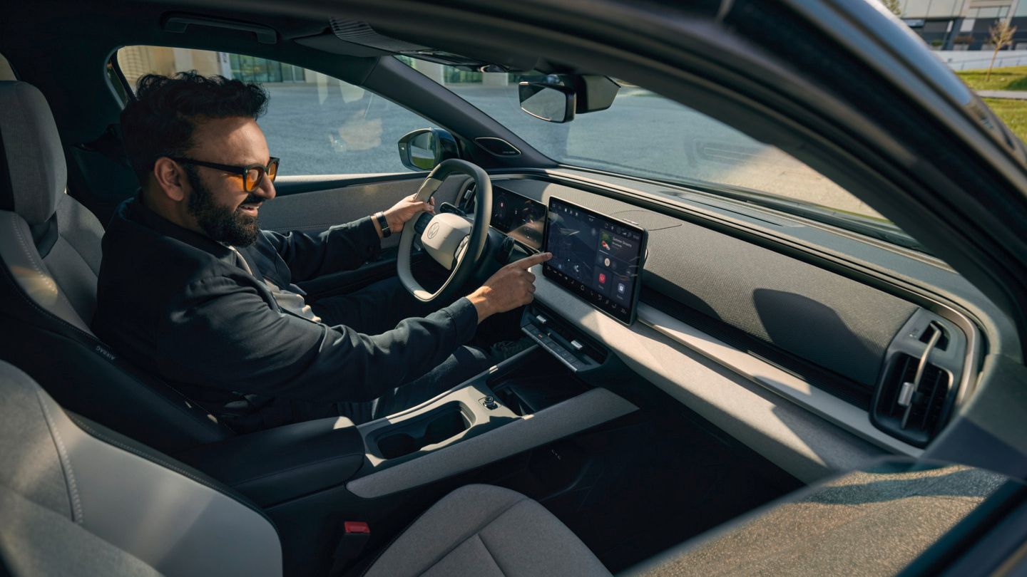 Muž sedí vo VW ID. Cross a ovláda infotainment systém.