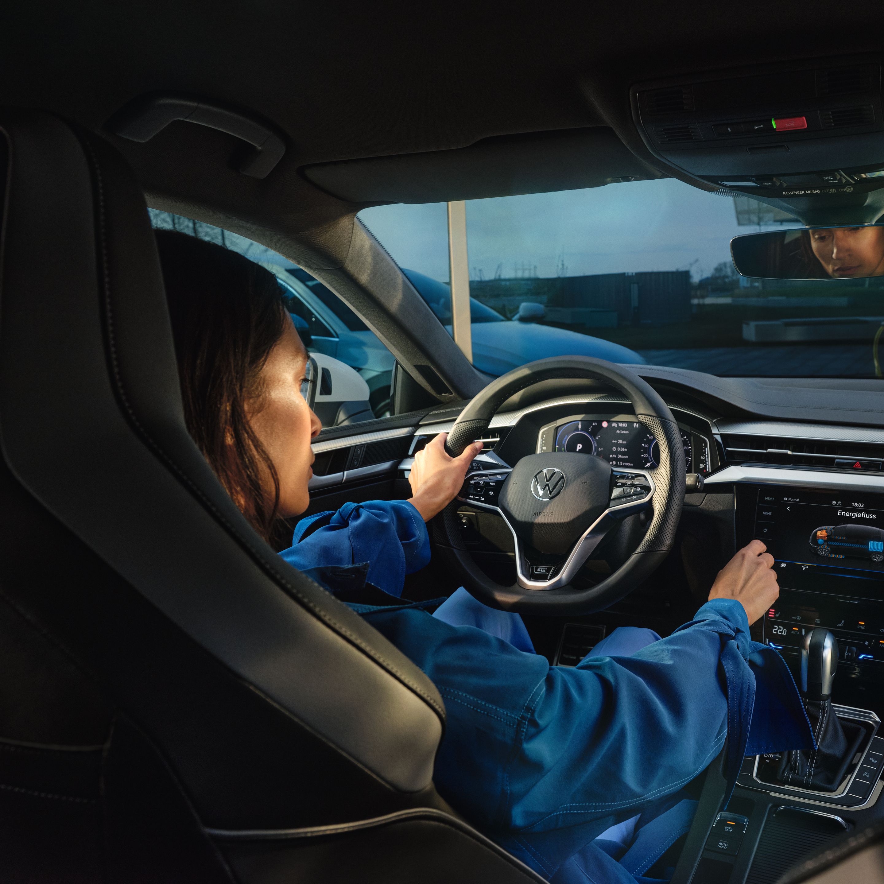 Žena sedí na sedadle vodiča vo vozidle Volkswagen. Nastavuje požadovanú teplotu klimatizácie.