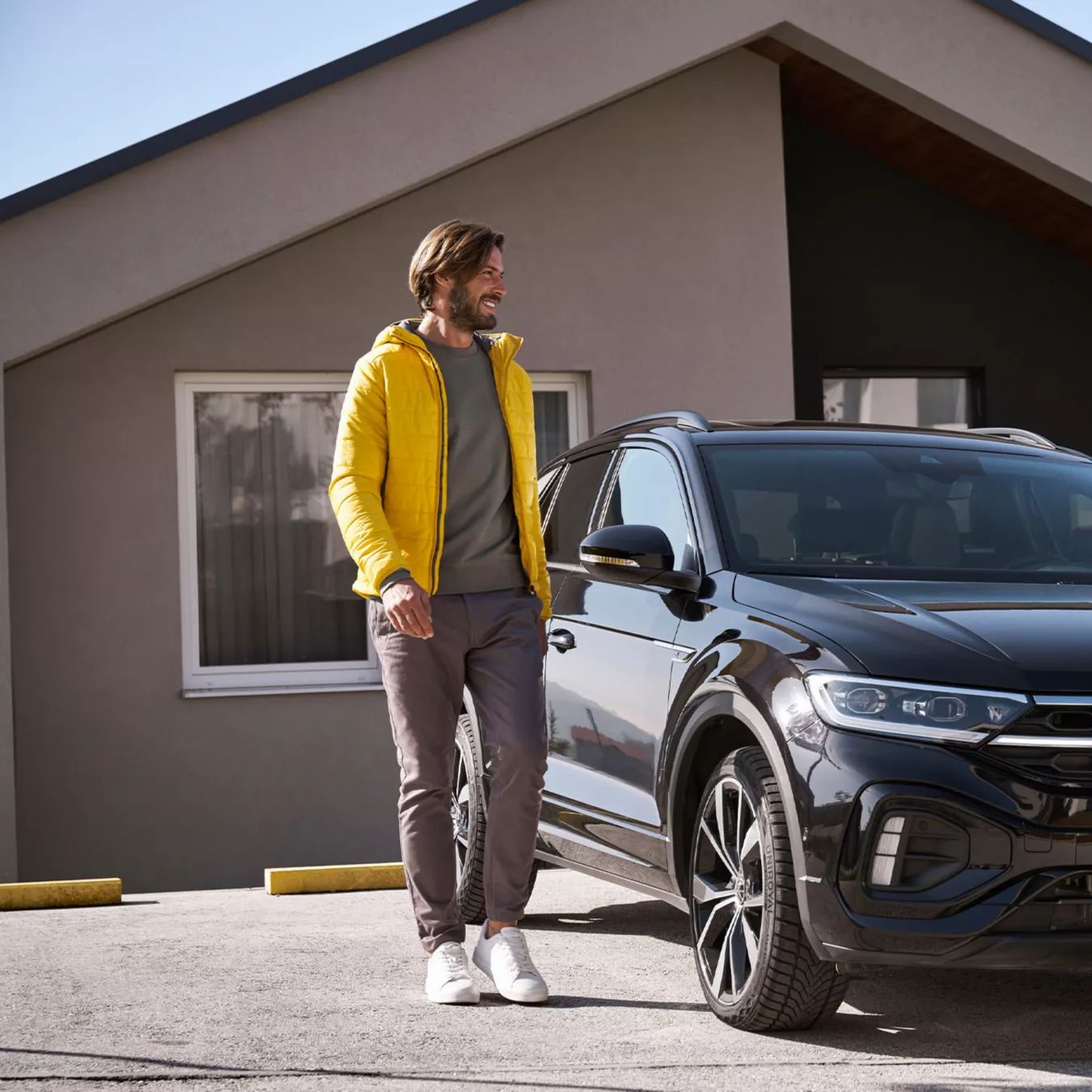 Žena so smartfónom a muž vedľa auta VW
